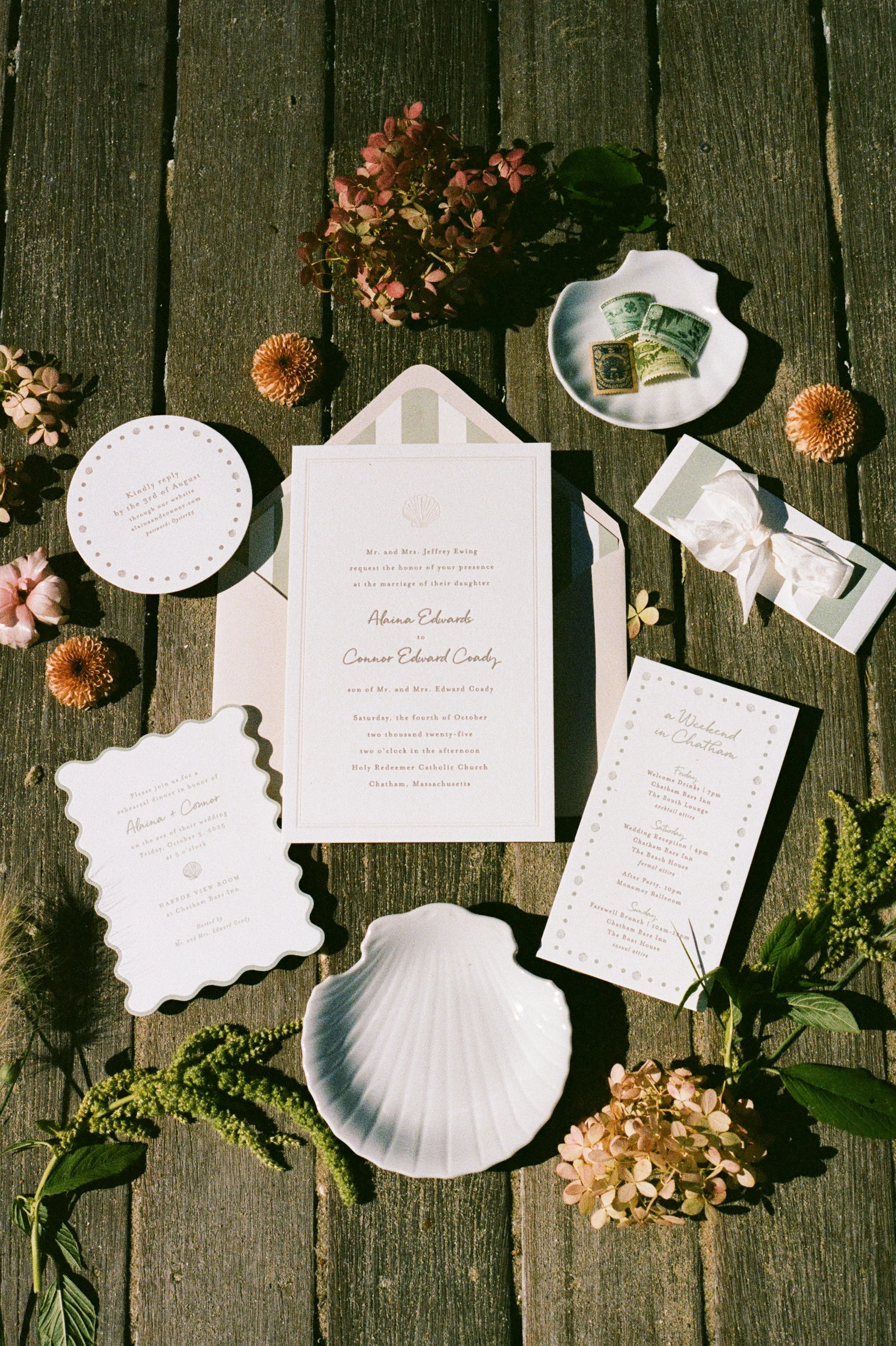 Wedding invitation suite with floral decorations and vintage currency on a wooden surface.