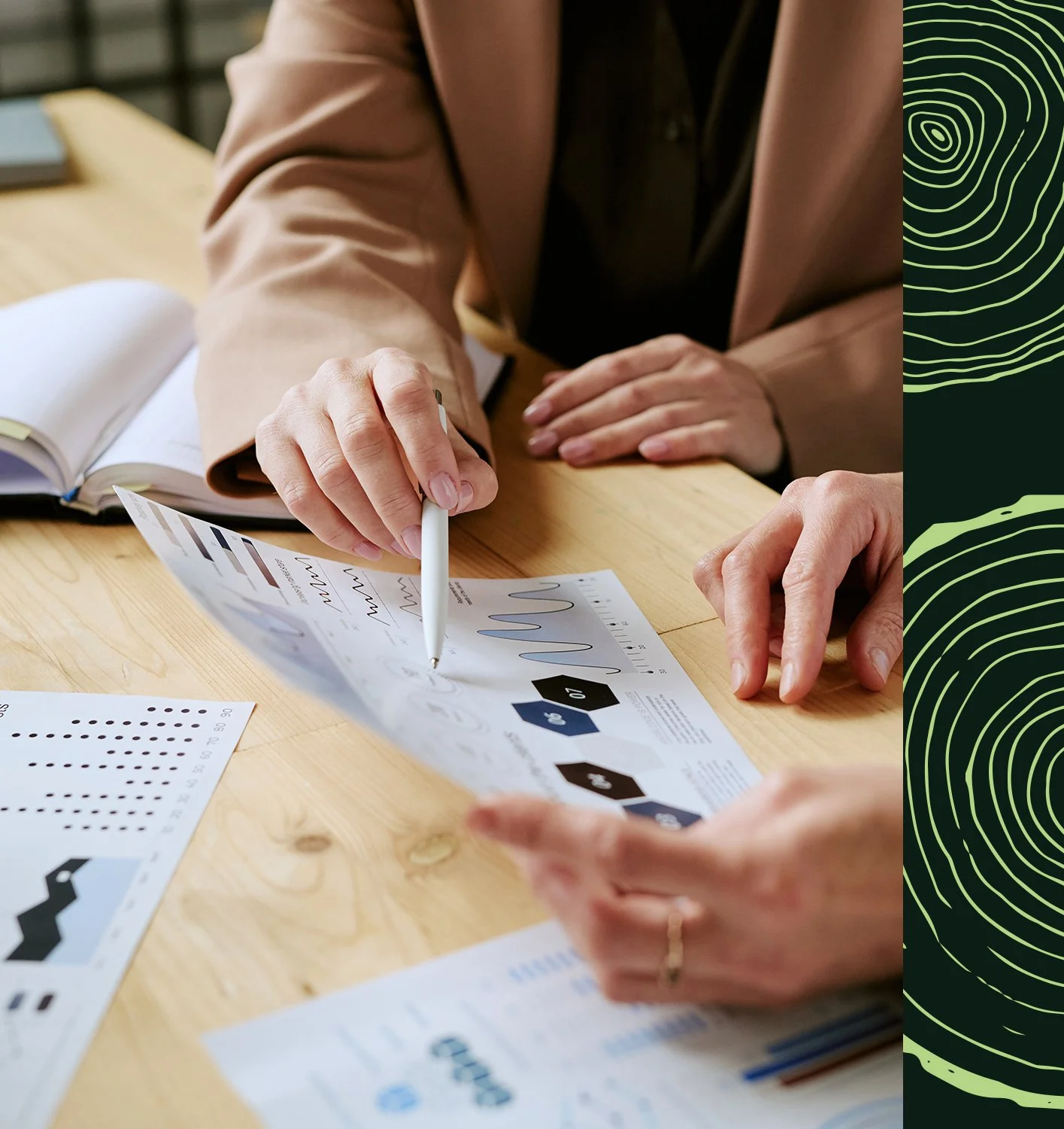 Deux personnes analysant des graphiques et des données lors d'une réunion de travail.