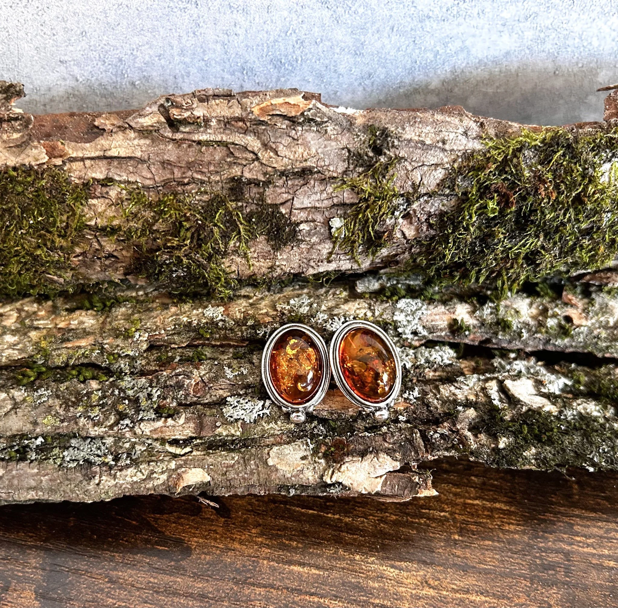 Silver stud earrings in oval shape with cognac amber