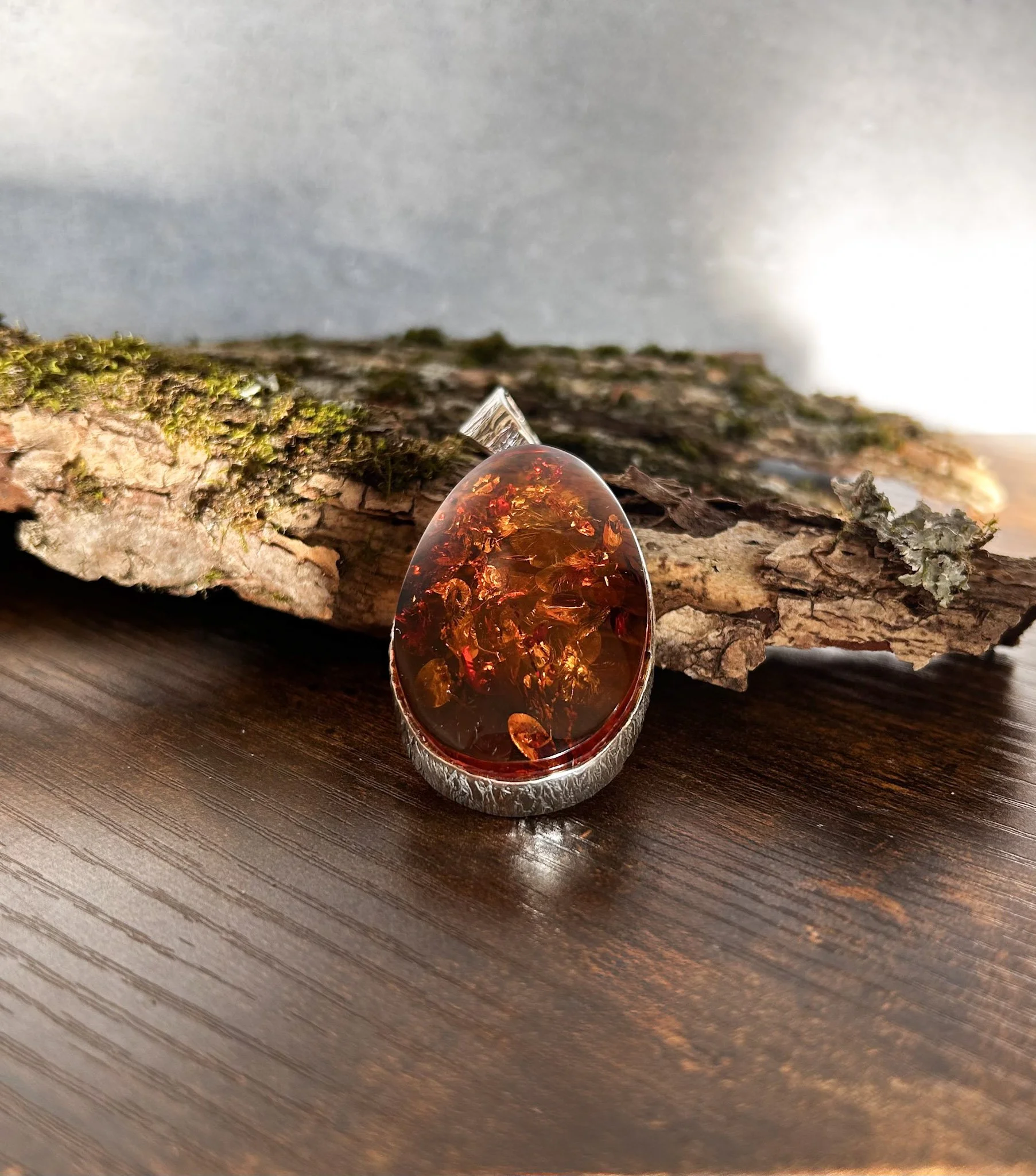 Oval shaped cognac Baltic amber pendant in silver