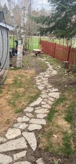 A stone pathway winding through a backyard, 