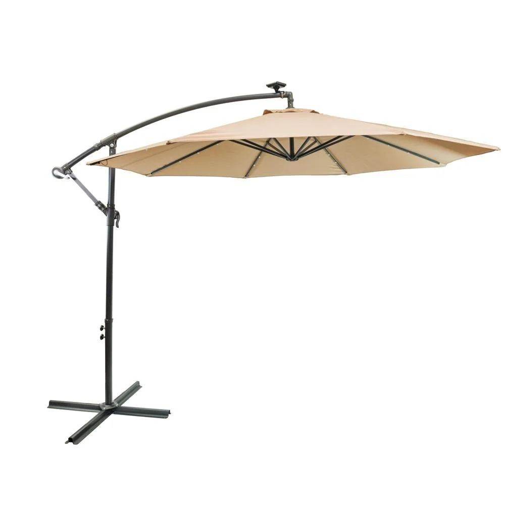 A beige outdoor patio umbrella with a black metal stand and a curved arm for shading.