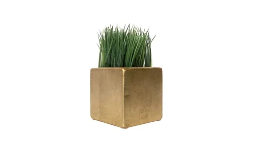 A small square gold-colored planter with green grass inside.