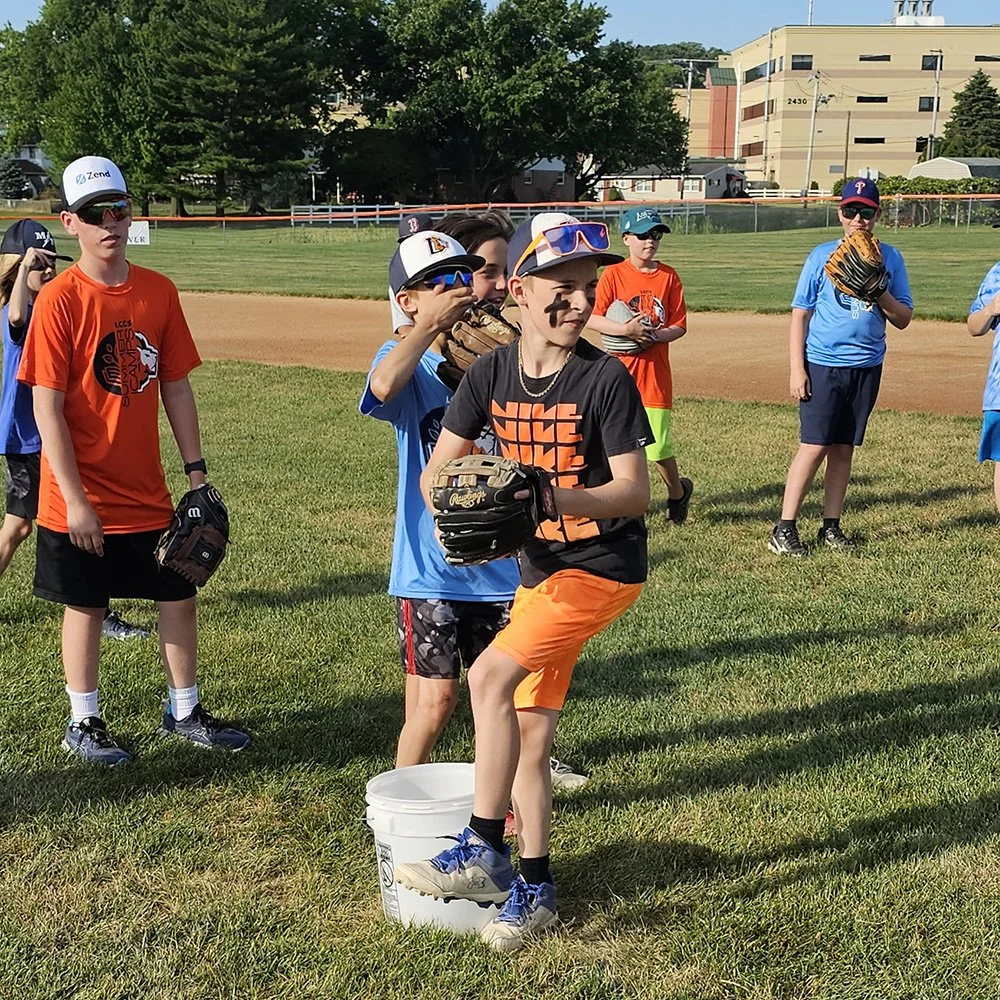 Young campers with gloves and sunglasses on a baseball field
