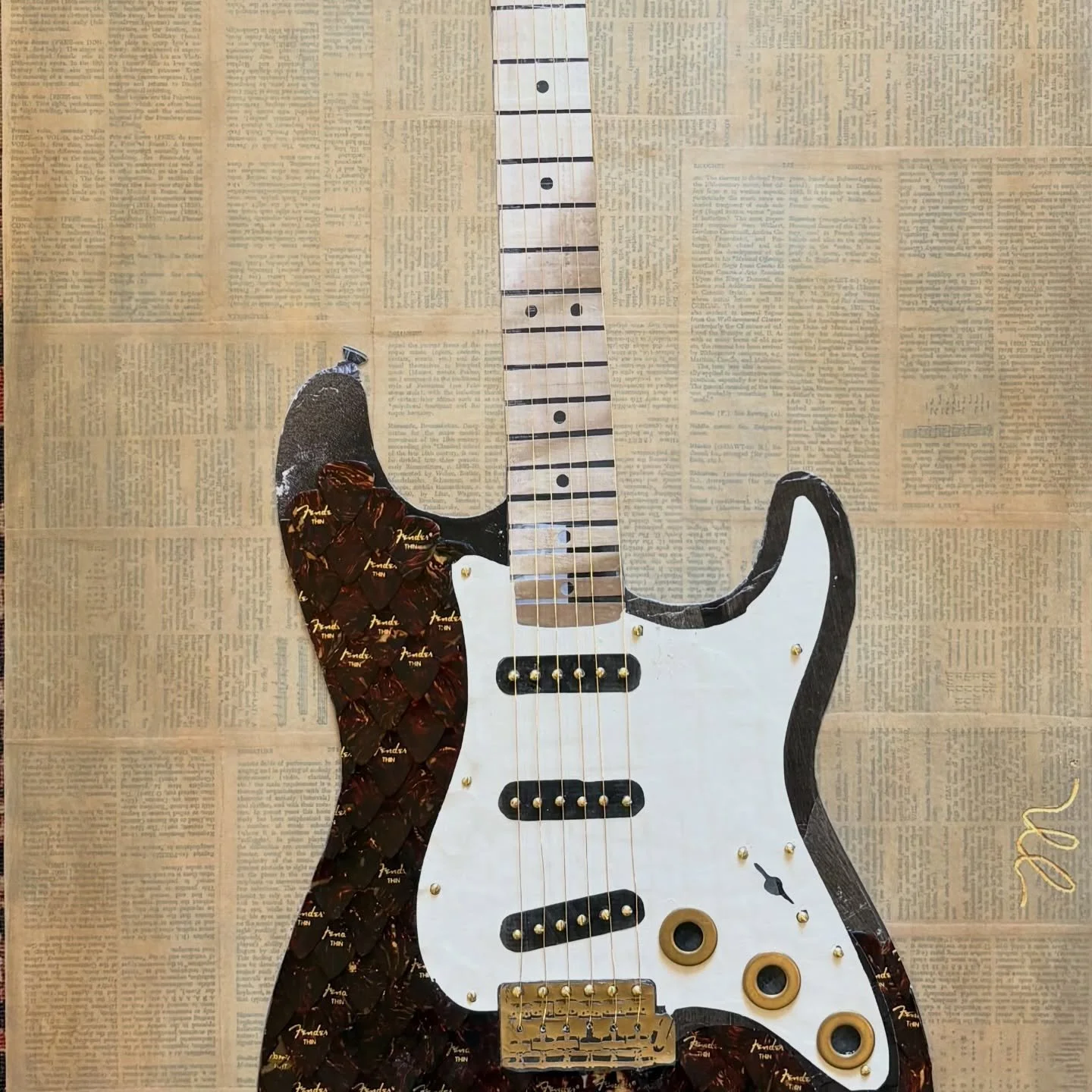 Meet Stevie. Inspired by the Fender Stratocaster and the blues. This electric guitar is pieced together with Fender guitar picks and vintage magazines, finished with brass hardware. Her background is layered with pages from a music dictionary and was