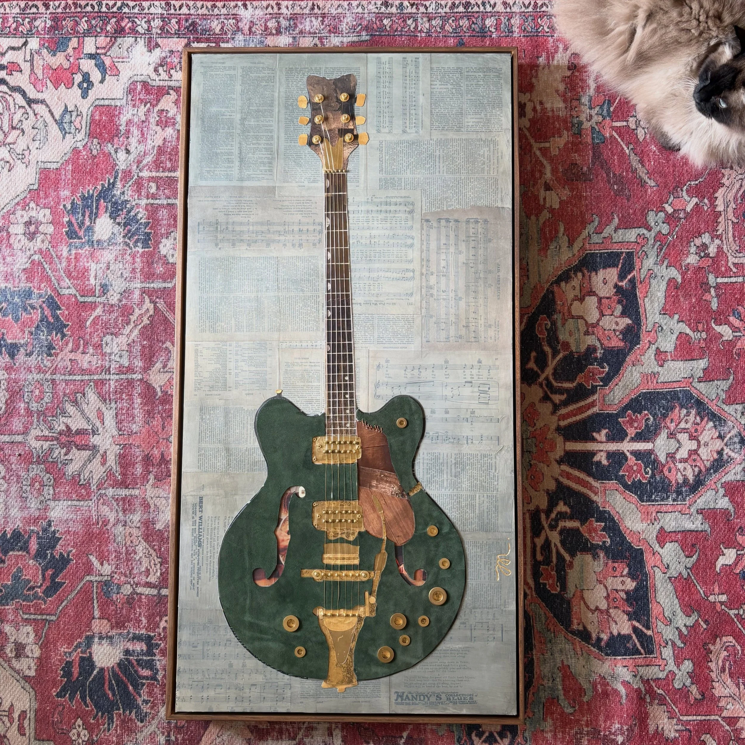 Meet Darlene. The latest paper, and suede, guitar. Pieced together with a variety of repurposed magazines and remnant olive green suede. The Gretsch style guitar sits on a 20&rdquo;x40&rdquo; wood panel layered with variety of vintage Blues music she