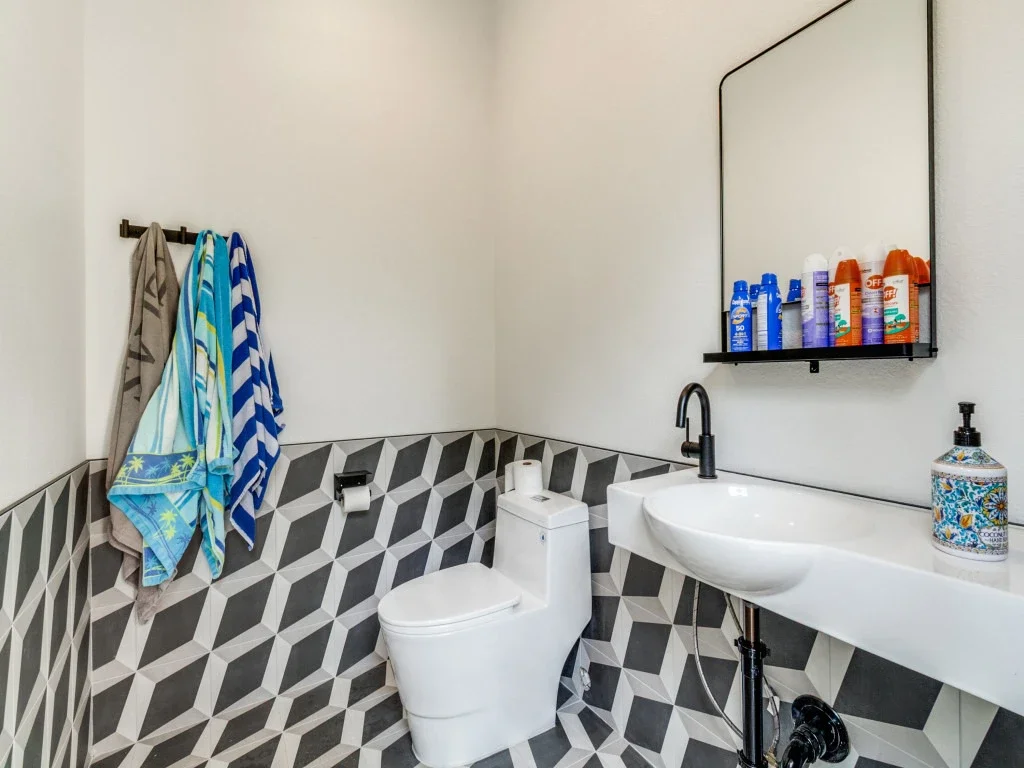 A pool bathroom with a cool tile feature.
