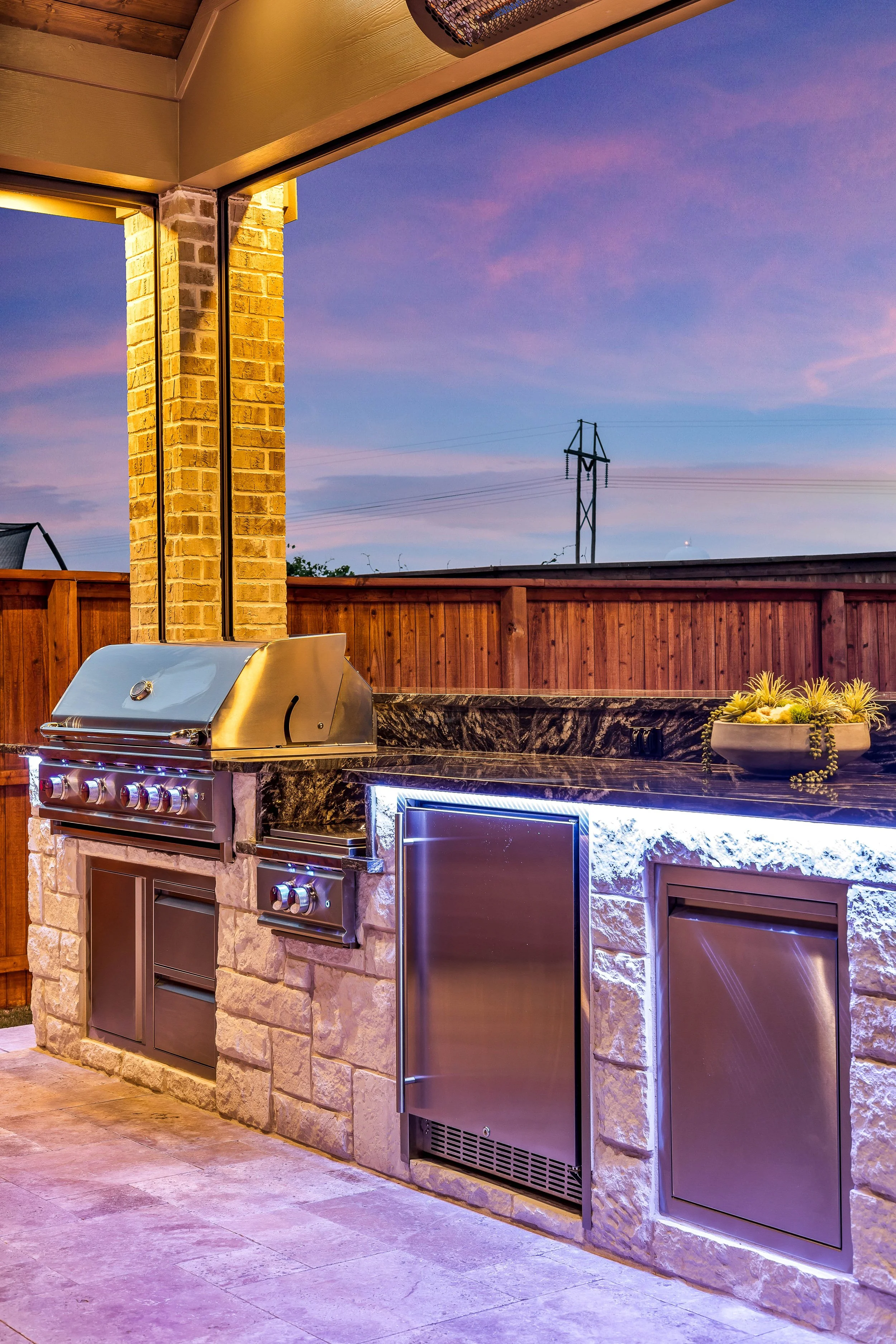 Custom outdoor living space featuring an outdoor kitchen and entertainment area built by TCP, an outdoor kitchen builder in DFW.