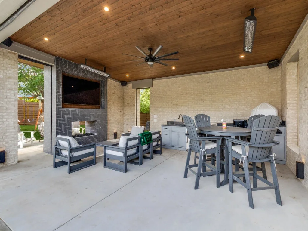 Tiled outdoor fireplace and outdoor kitchen with sink.