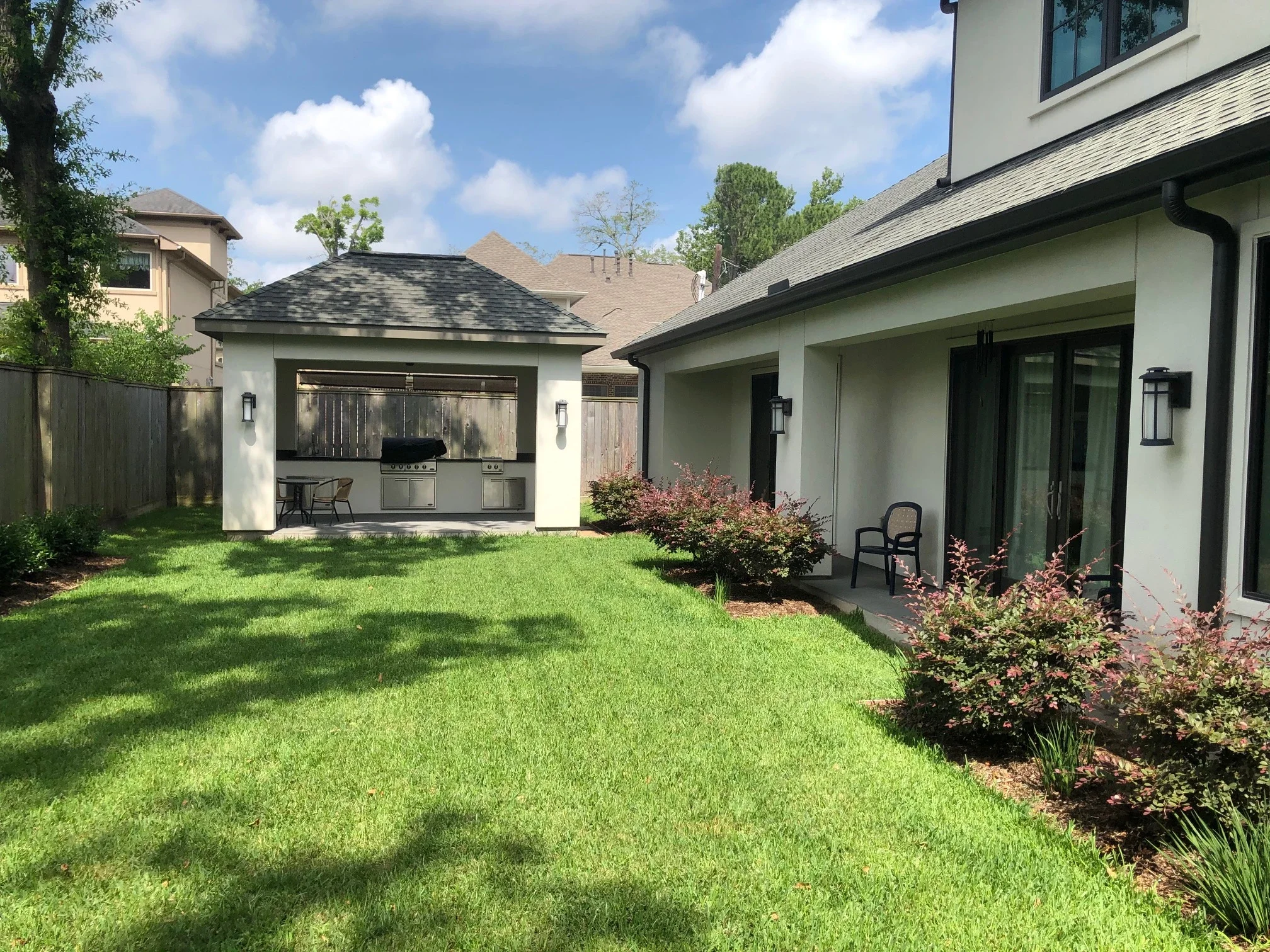 A before photo of a home with an attached patio cover, outdoor kitchen, pool, and spa.