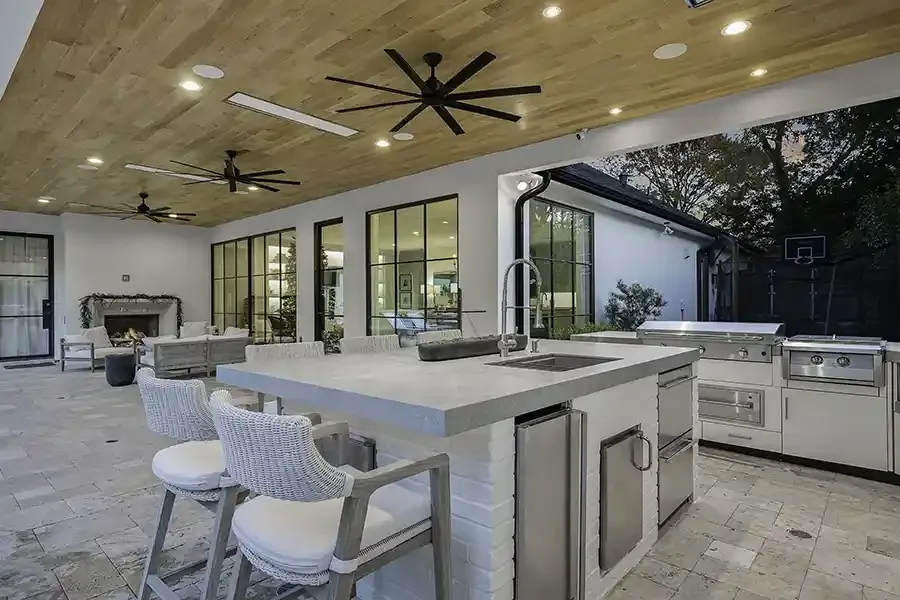 Modern Outdoor kitchen with sink in kitchen island showing white oak ceiling in Dallas Texas