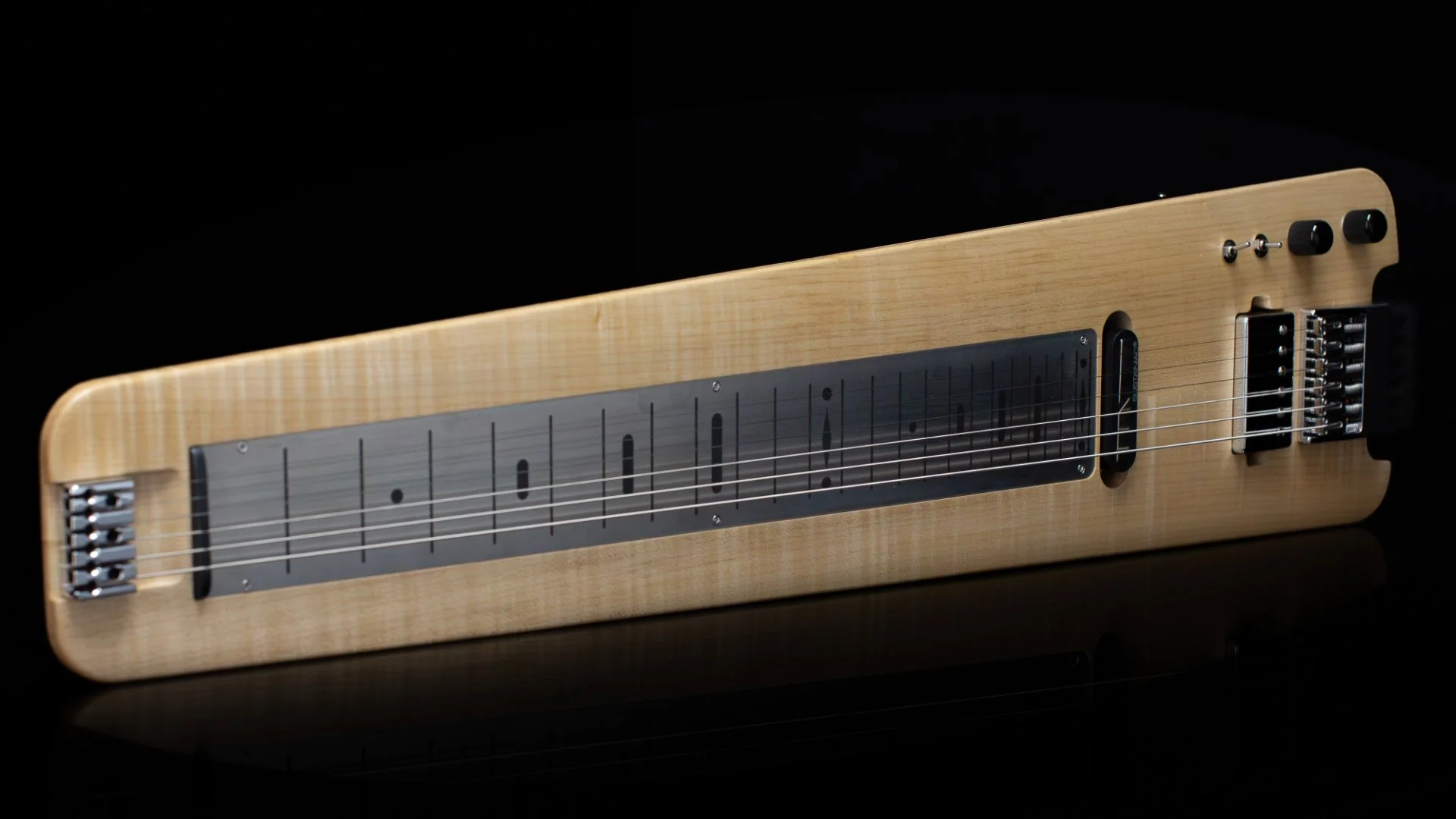 A modern headless -  electric lapsteel with a flame maple cap in a natural finish, HS pickups and a black background - Landscape view