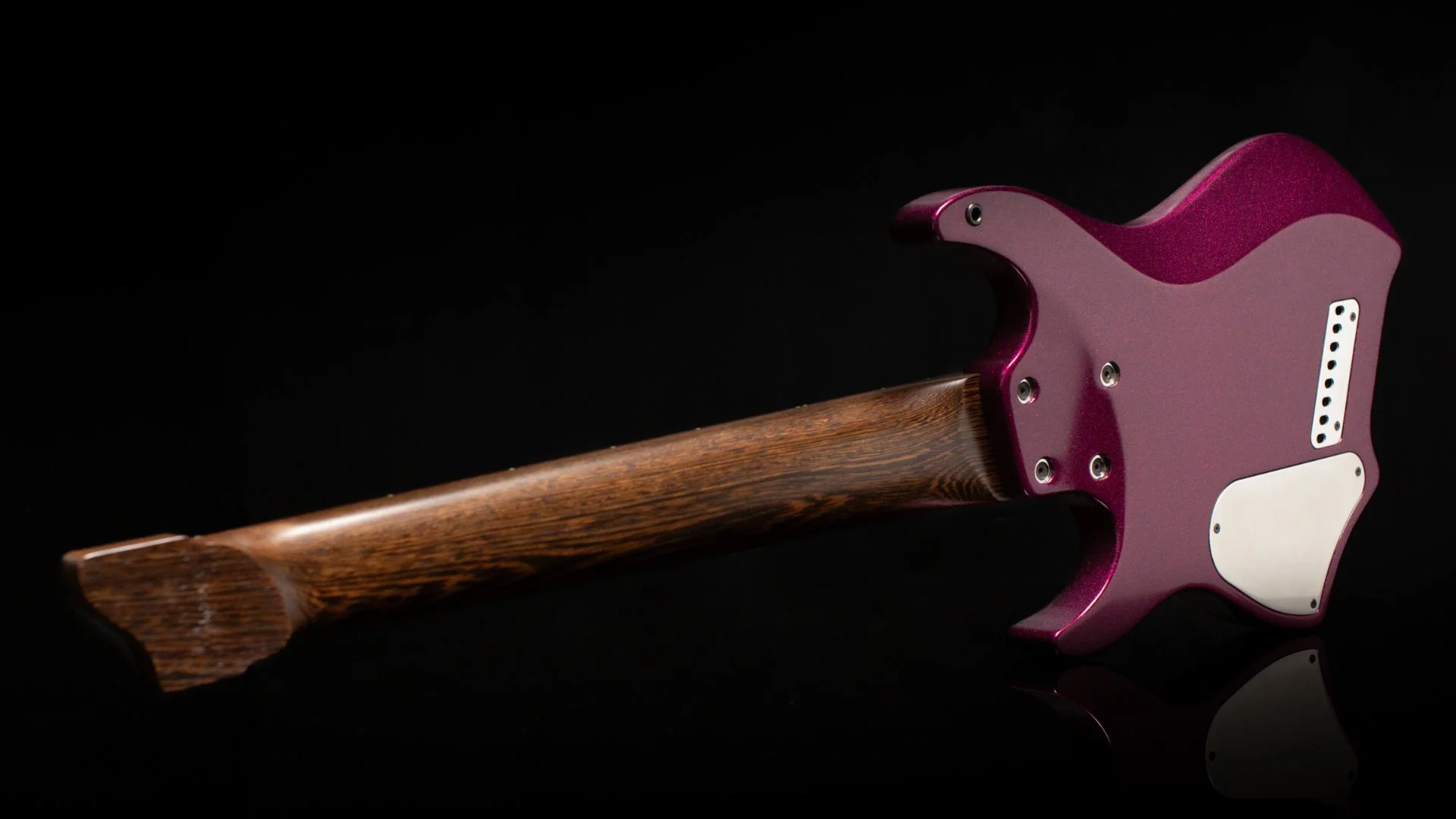 Back view of a headless multiscale 8 string guitar highlighting the african wenge neck and chrome back plates