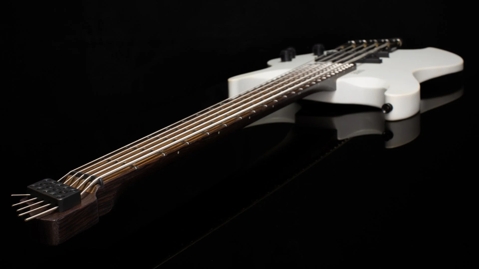 Neck view of a white 5 string headless multiscale bass focussing on the inlaid zebrano fretboard