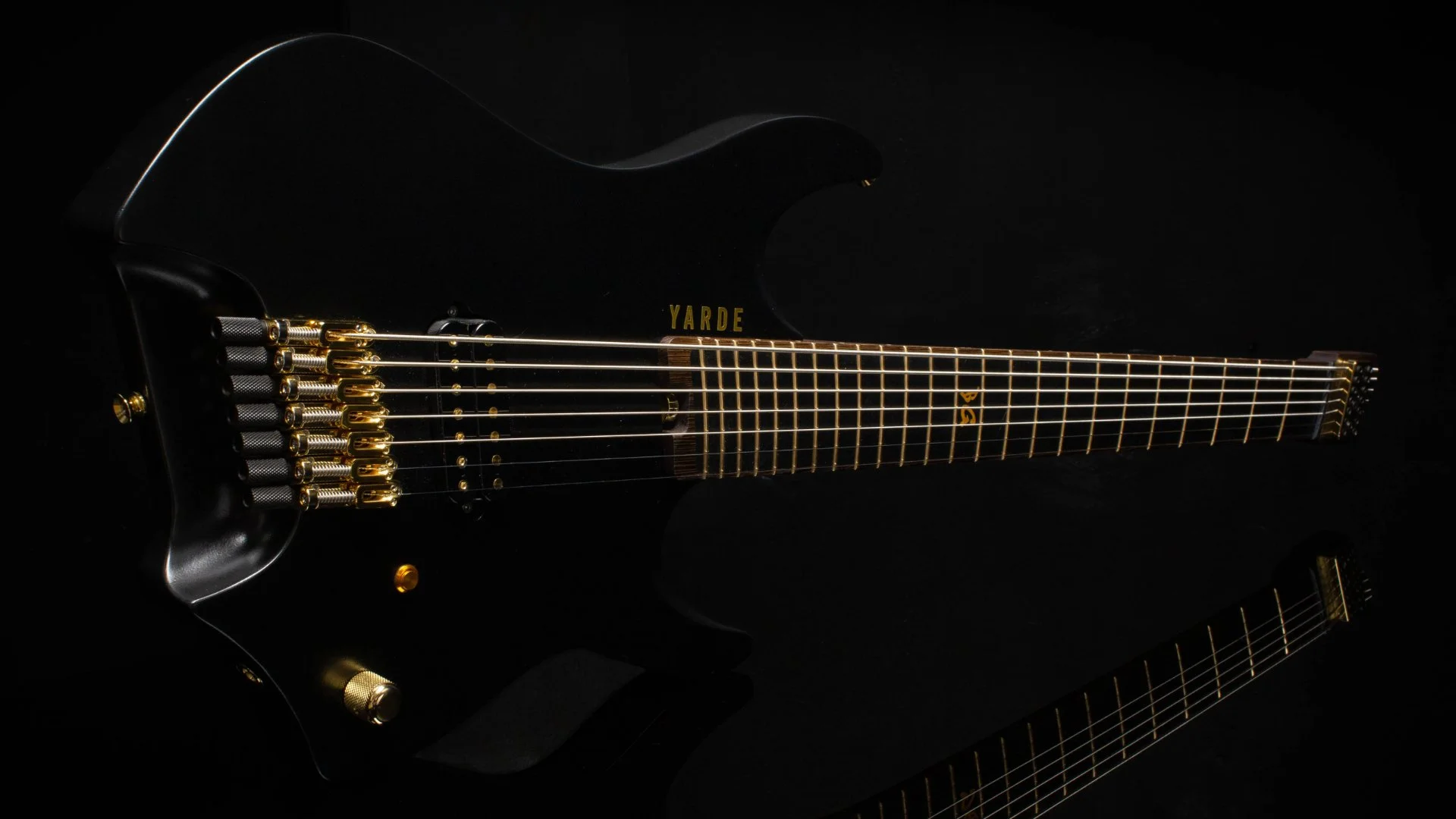 A black painted headless - multiscale electric guitar with gold hardware - landscape view