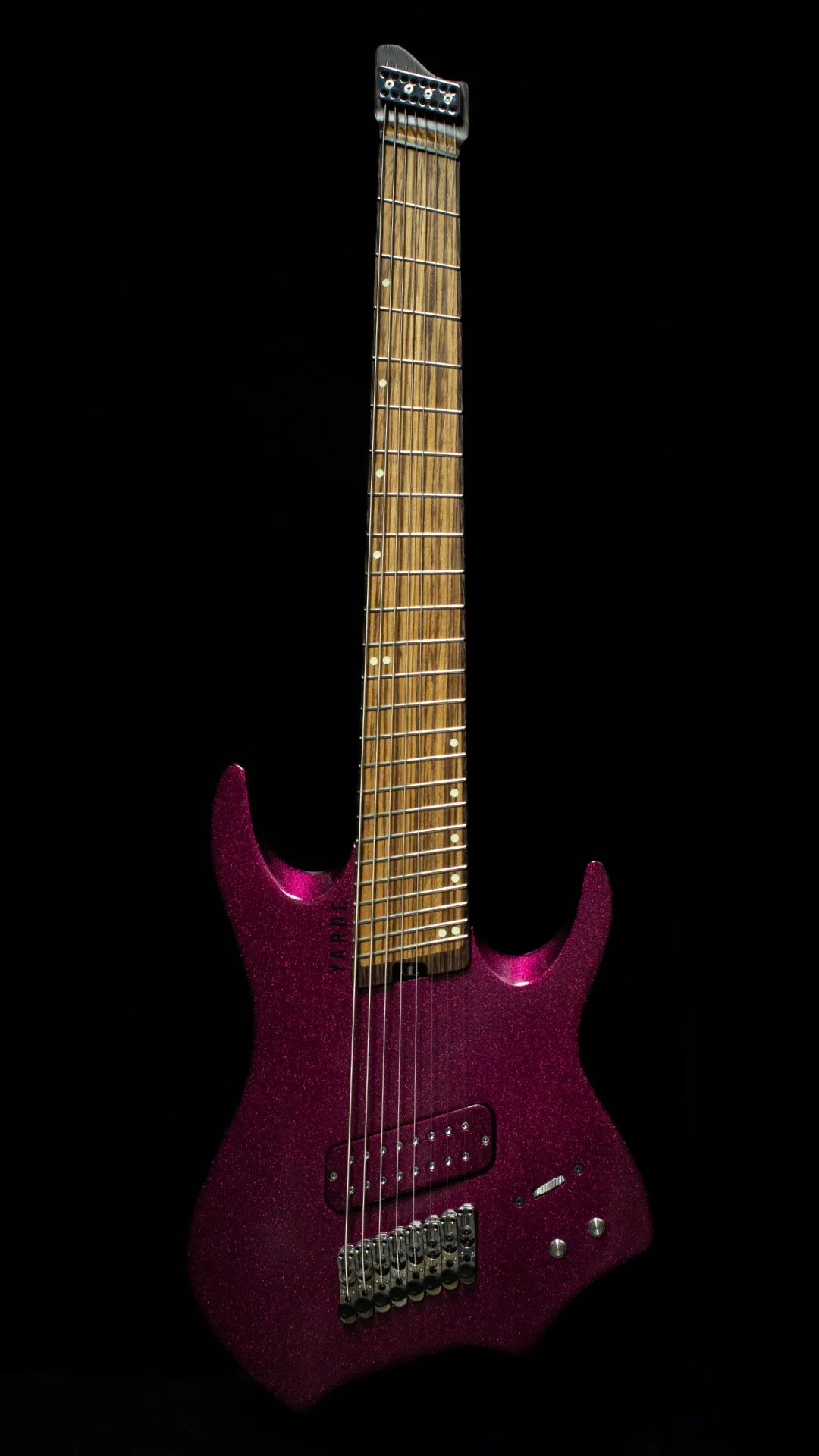 8 String Headless - Multiscale electric guitar in a sparkle pink against a bblack background