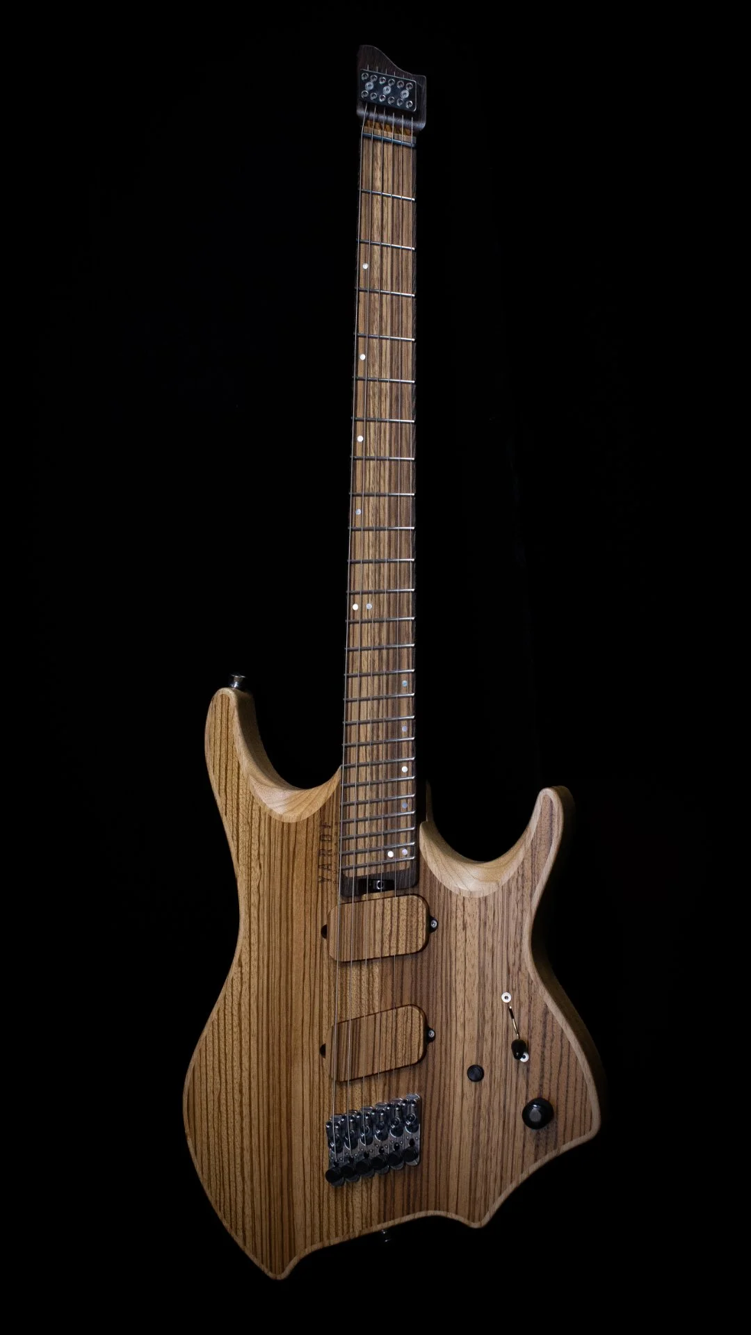 A headless - multiscale electric guitar with an inlaid cap in a natural finish, set against a black background - Portrait view