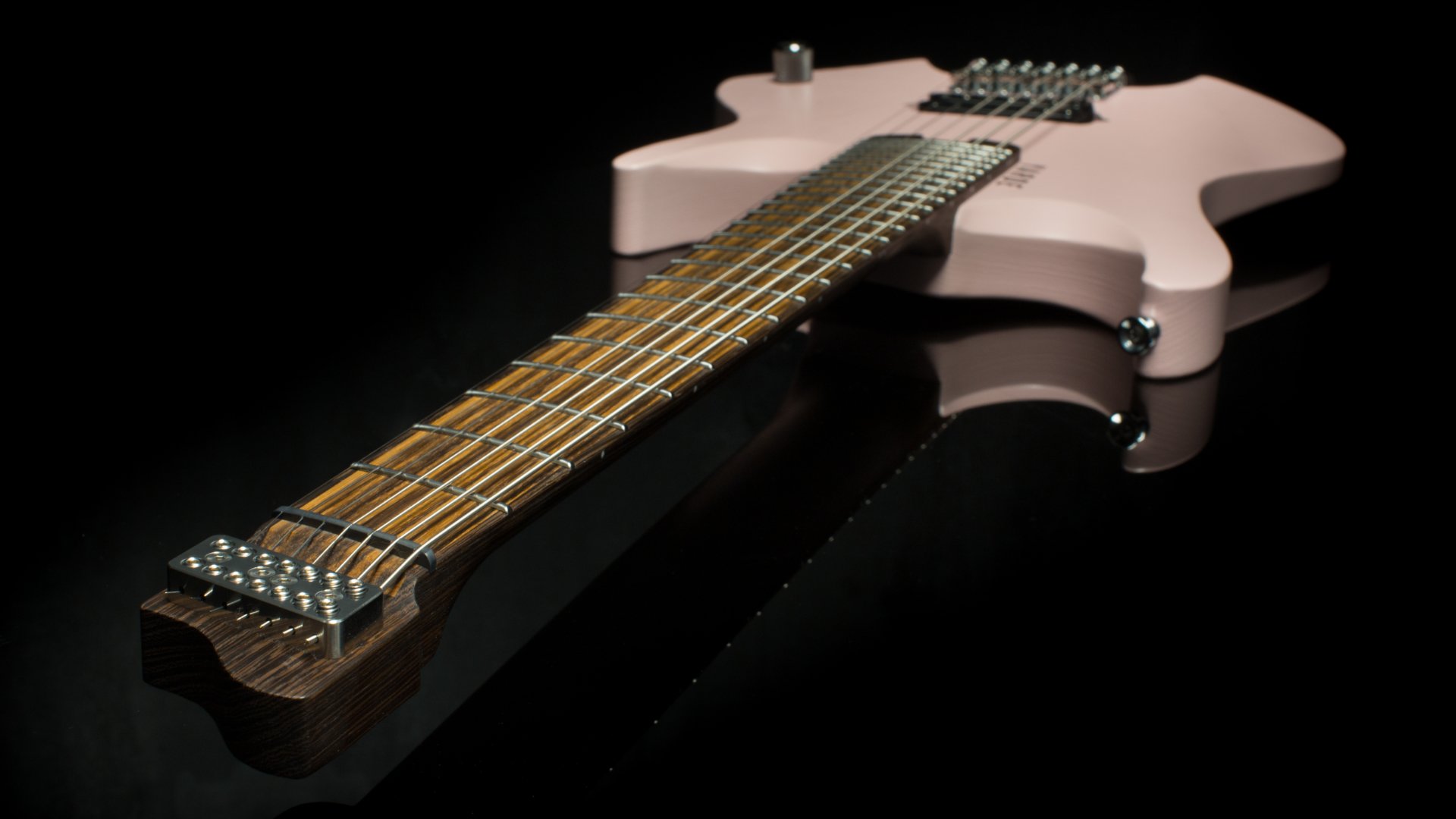 A pink 7 string headless - multiscaled electric guitar focussing on the inlaid zebrano fretboard