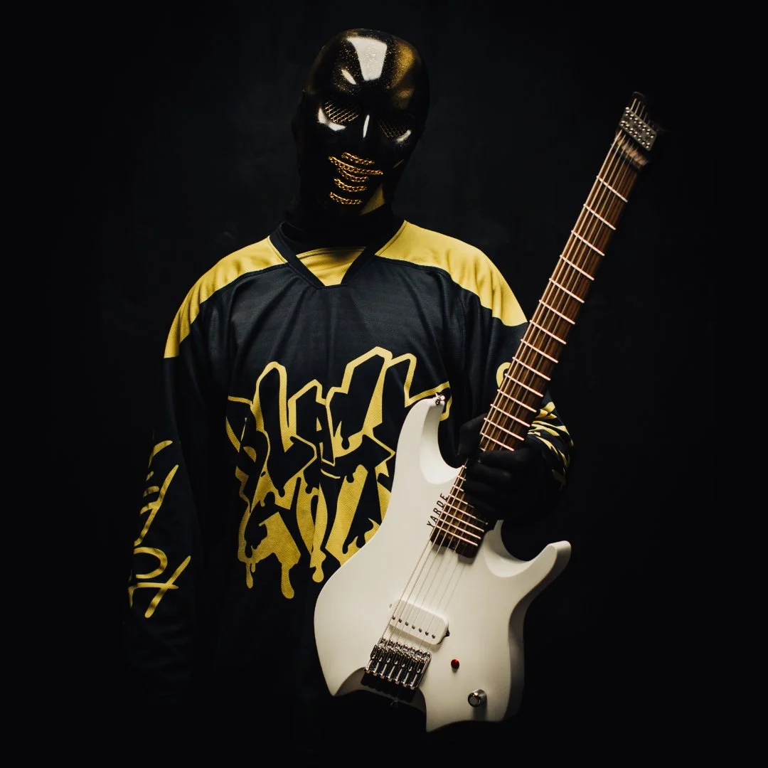 Nu-Metal guitarist 'JUDGE' holding a white 7 string headless multiscale electric guitar
