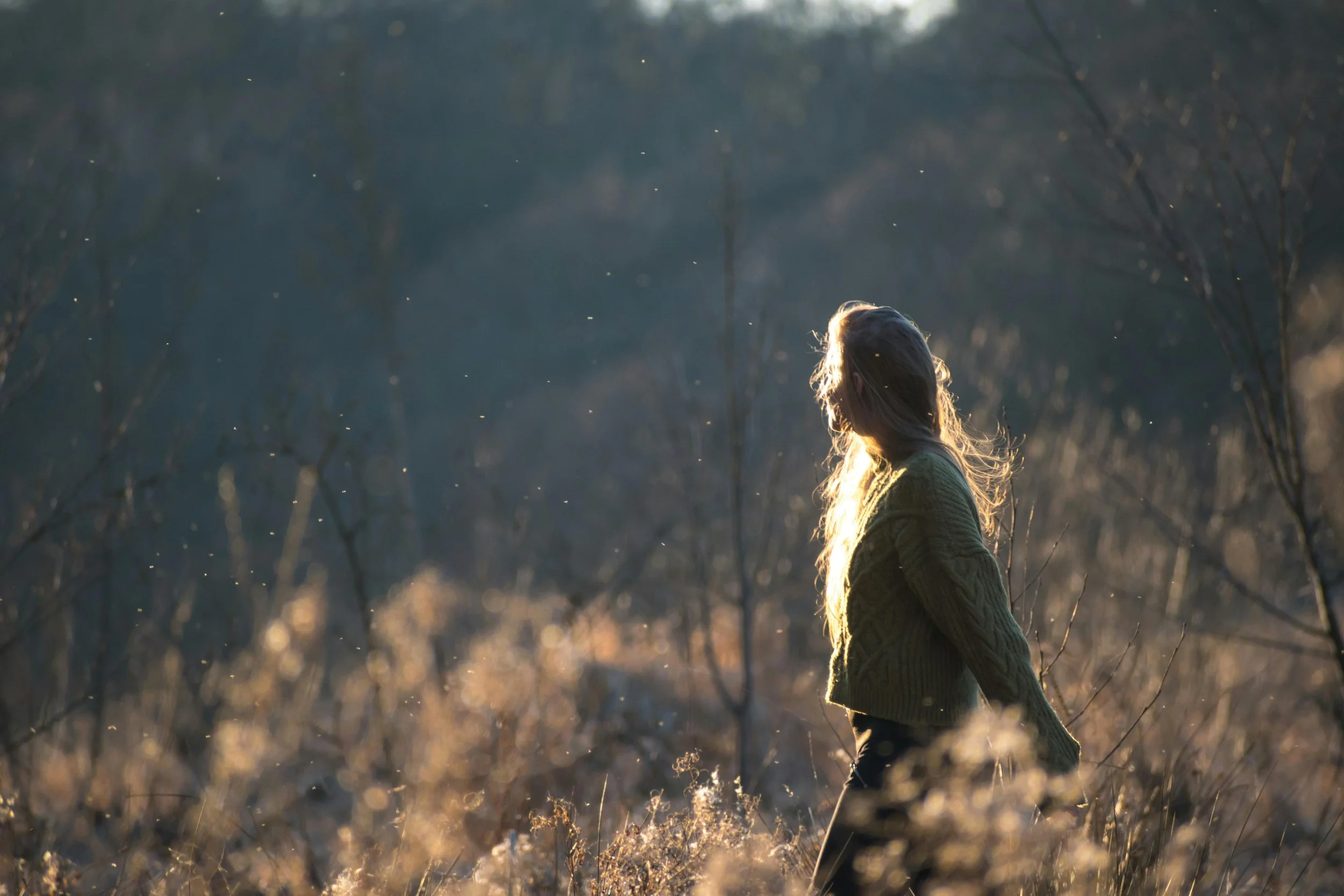 Woman walking outside in soft morning light, representing the gradual, non-linear process of healing after miscarriage grief