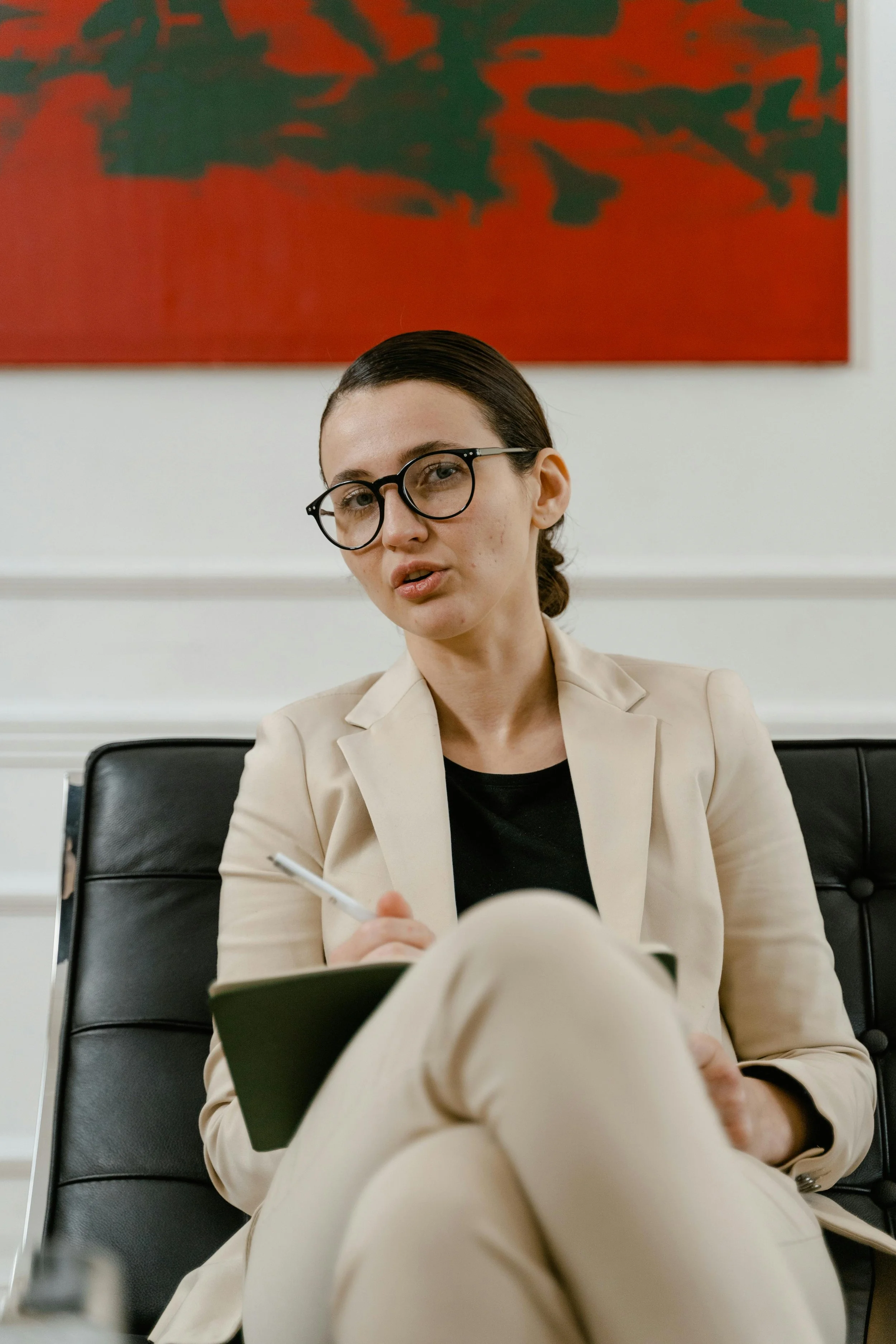 A female therapist in Texas taking notes during a client session in a calm, professional office setting.