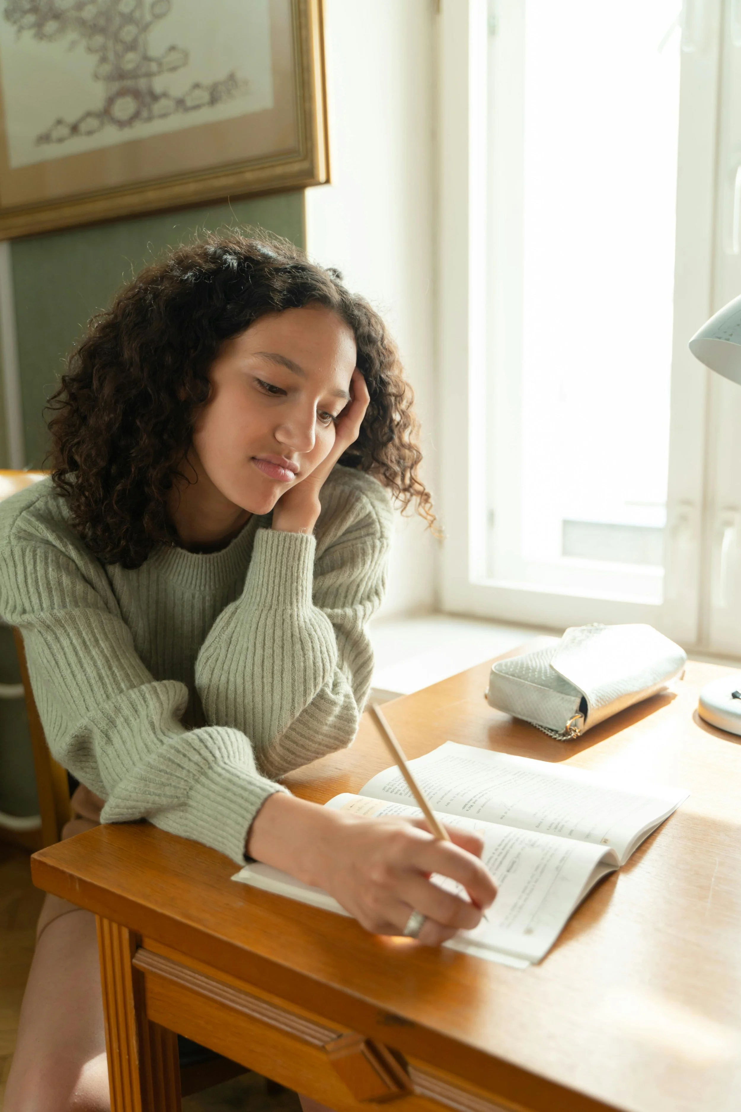 A graduate student studying psychology or counseling at a desk with textbooks and notes.