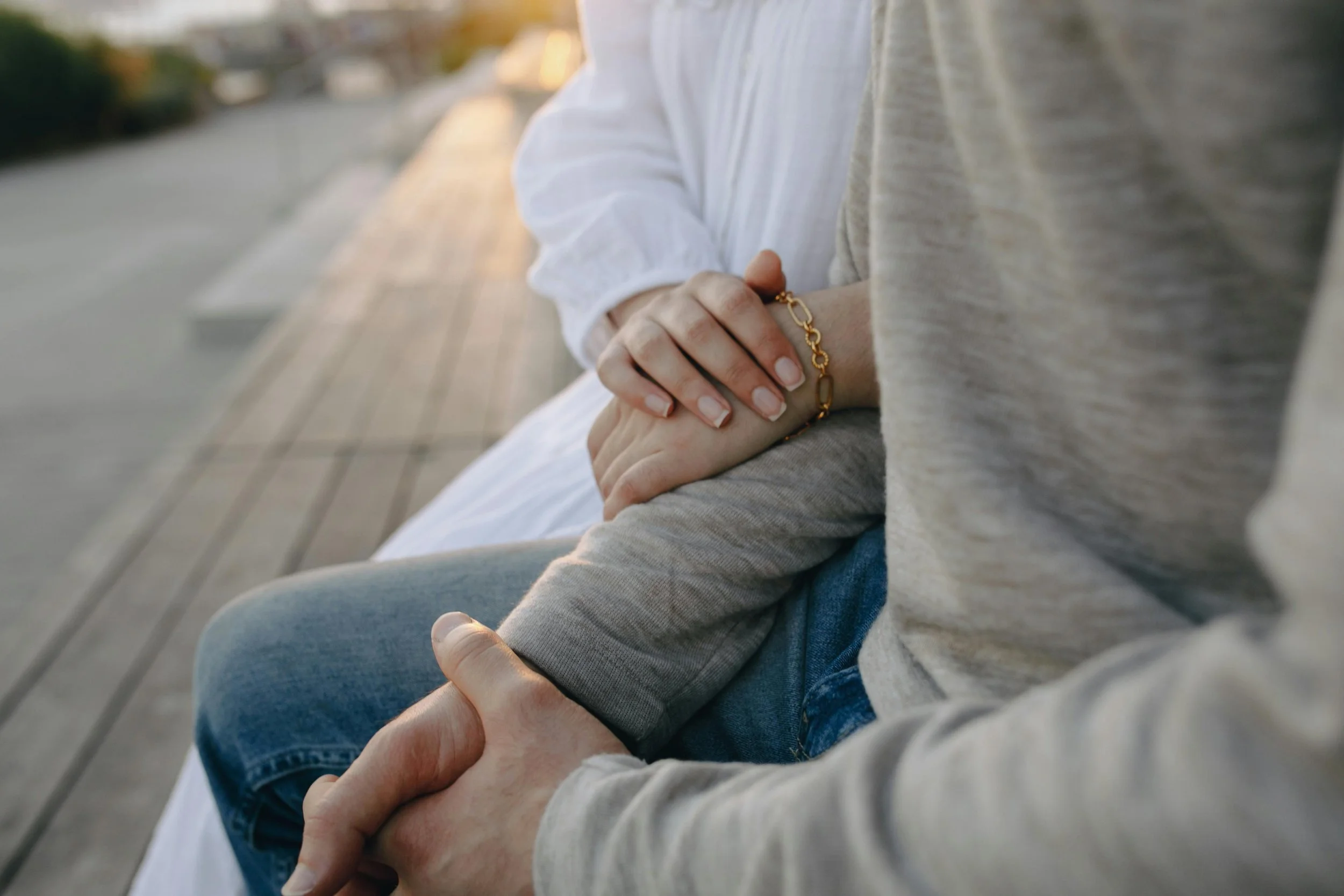 A couple sitting close together in a quiet moment, representing how partners may grieve a miscarriage differently but still support each other