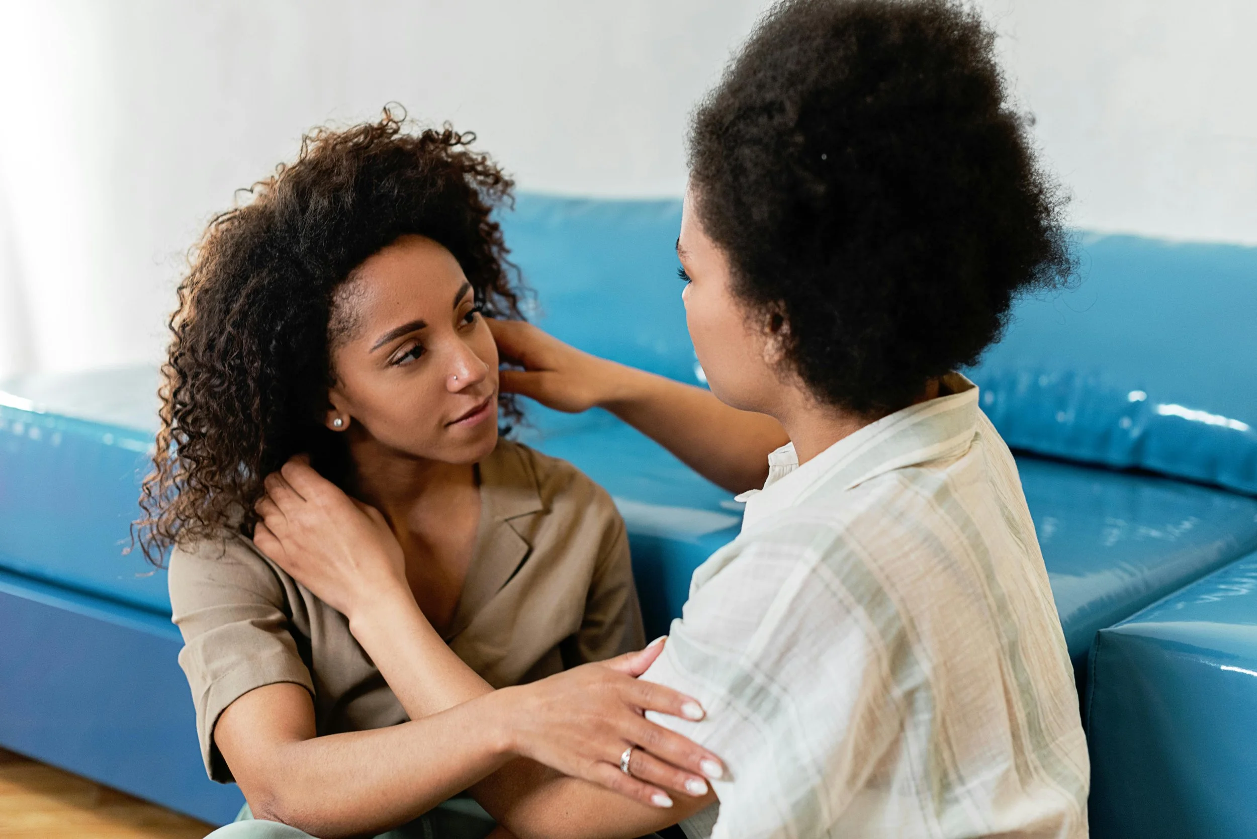 Two women sitting together in quiet support, illustrating the importance of having someone acknowledge your grief after miscarriage