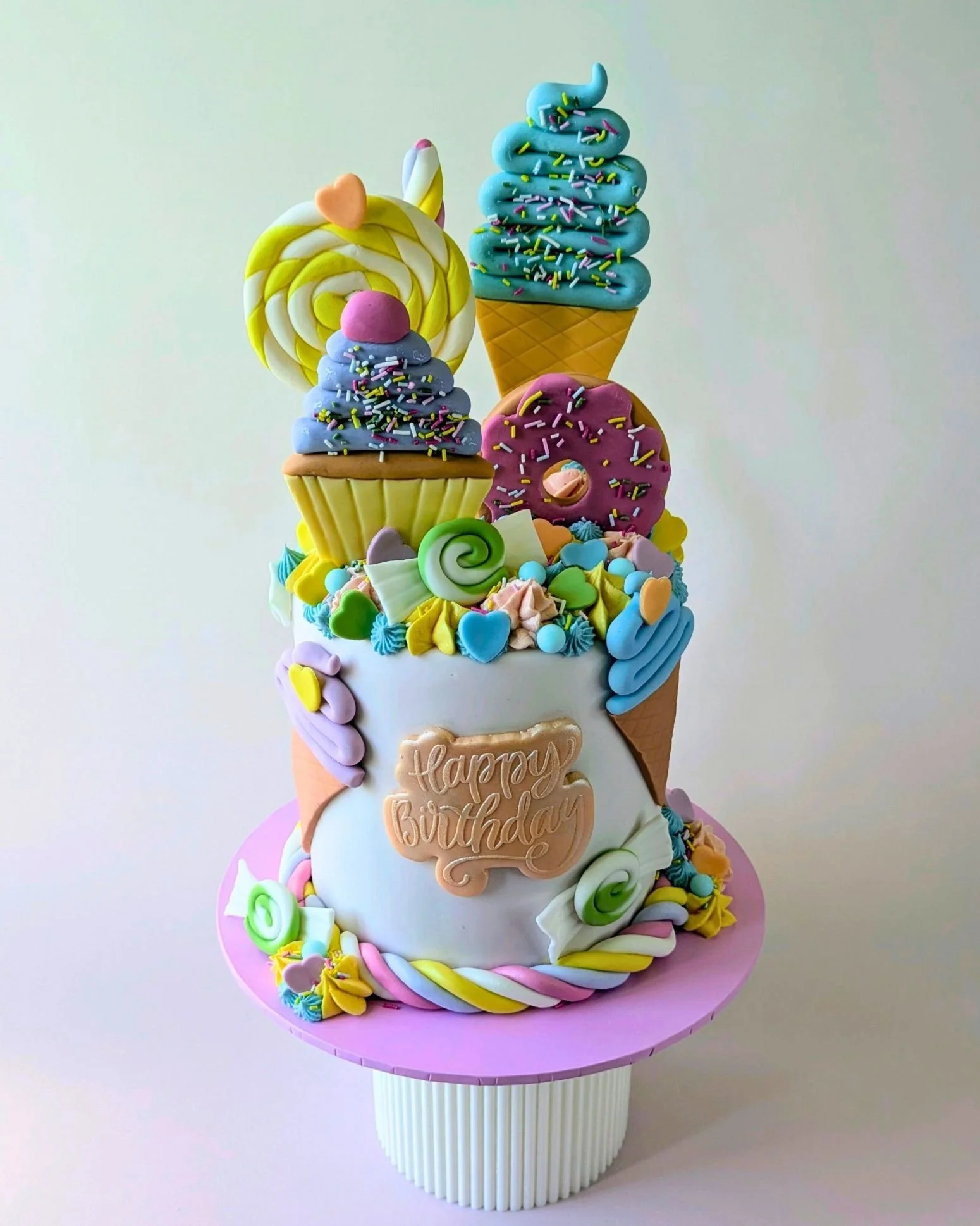 bright and colourful sweet and ice cream themed vegan birthday celebration cake.