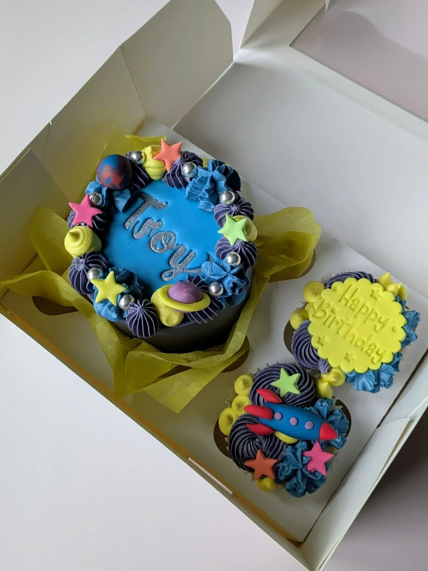 Colourful space themed bento cake with handmade rocket and planet decorations from vegan cake shop in Bristol