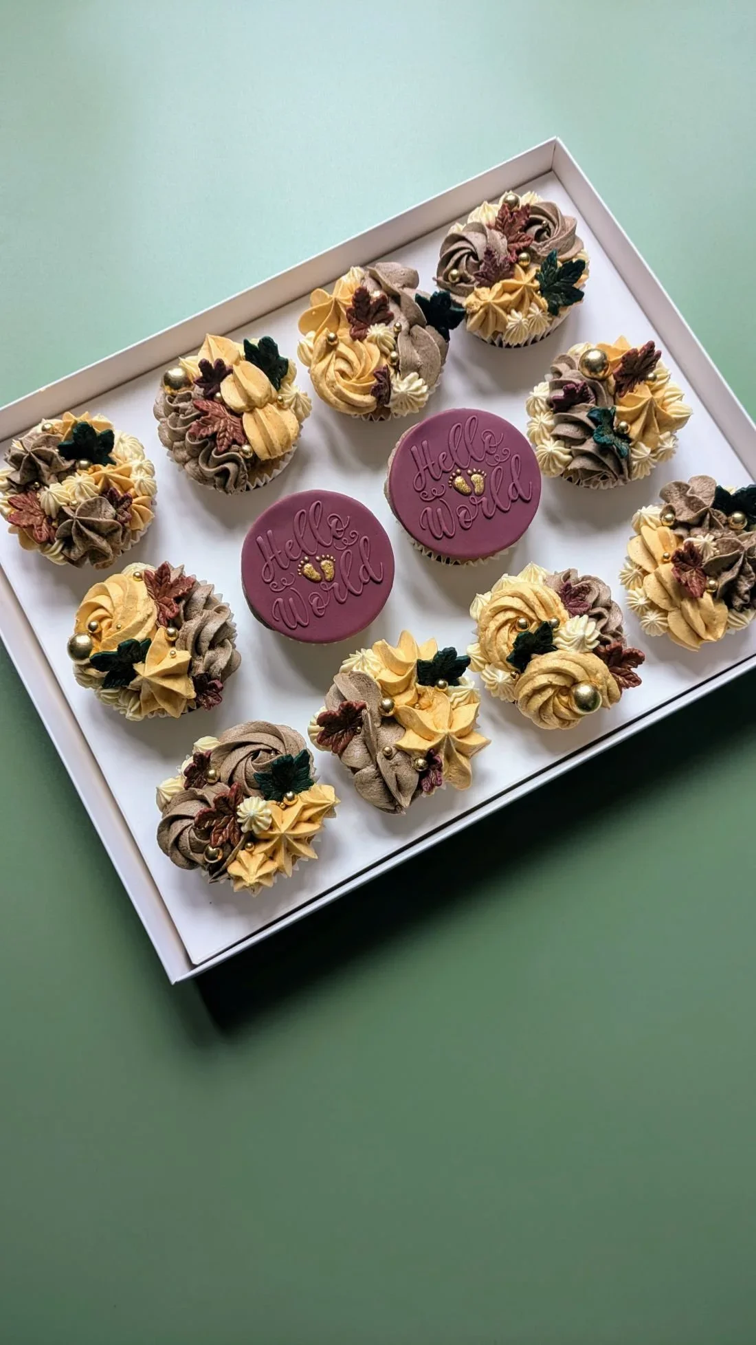 Autumnal baby shower cupcakes with gold buttercream and burgundy red toppers from vegan cake shop in Bristol