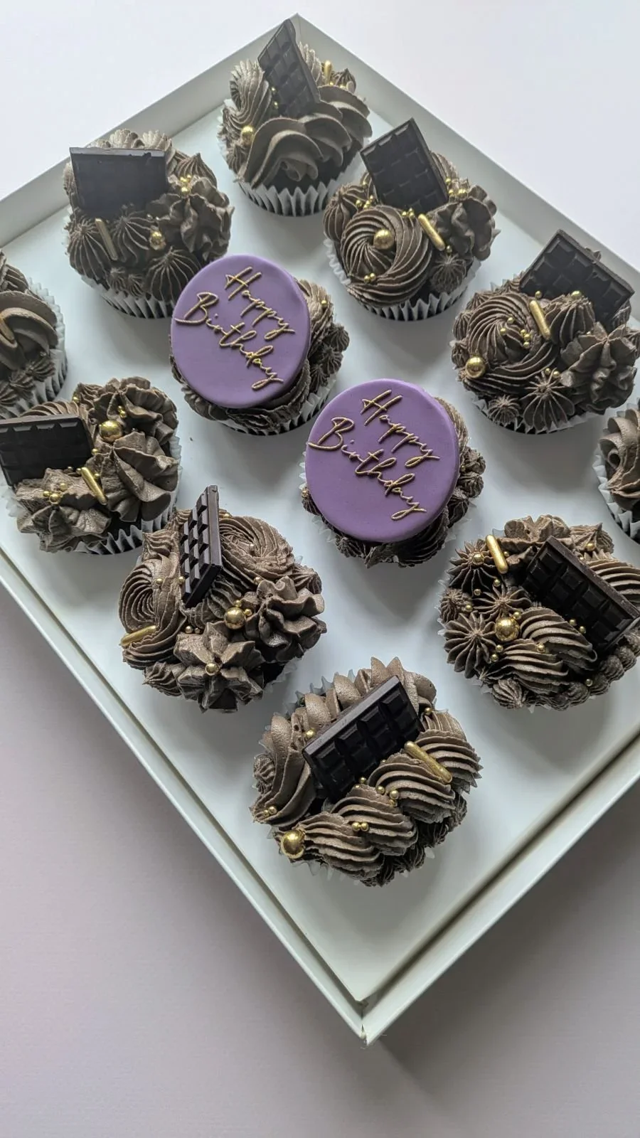 Chocolate cupcakes with purple birthday message toppers and swirl frosting from vegan cake shop in Bristol