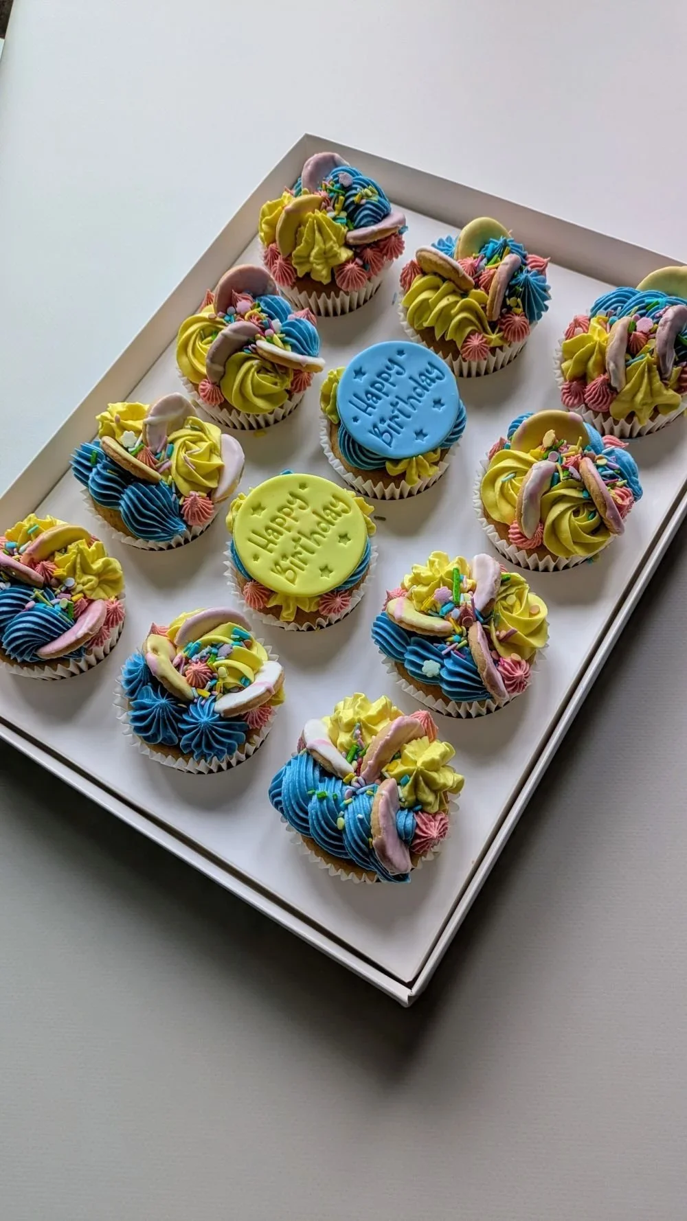 Vegan multicoloured lemon and raspberry cupcakes with party rings and sprinkles from vegan cake shop in Bristol