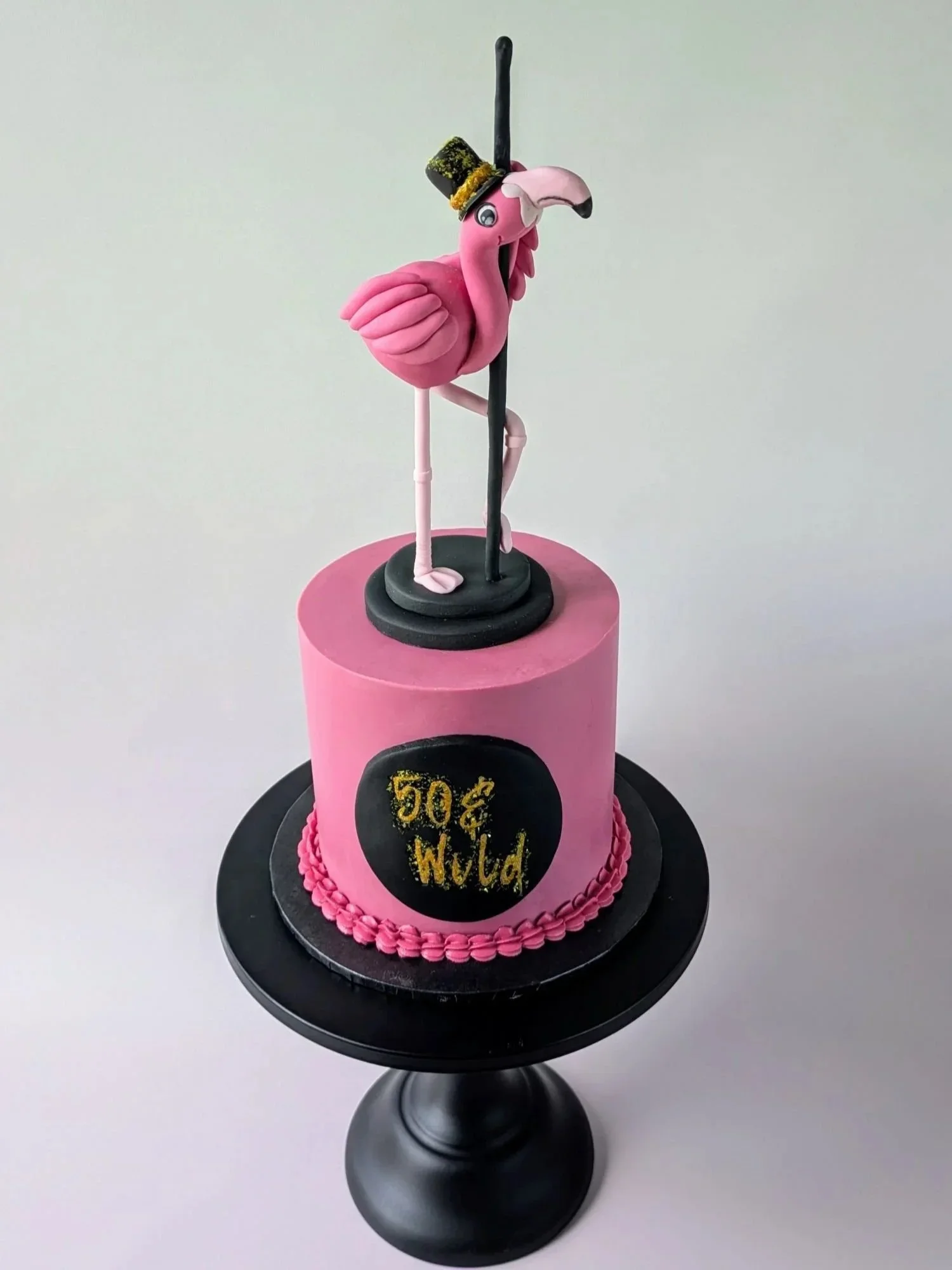 Custom celebration cake featuring handmade flamingo pole dancer with top hat decoration, celebration cakes Bristol