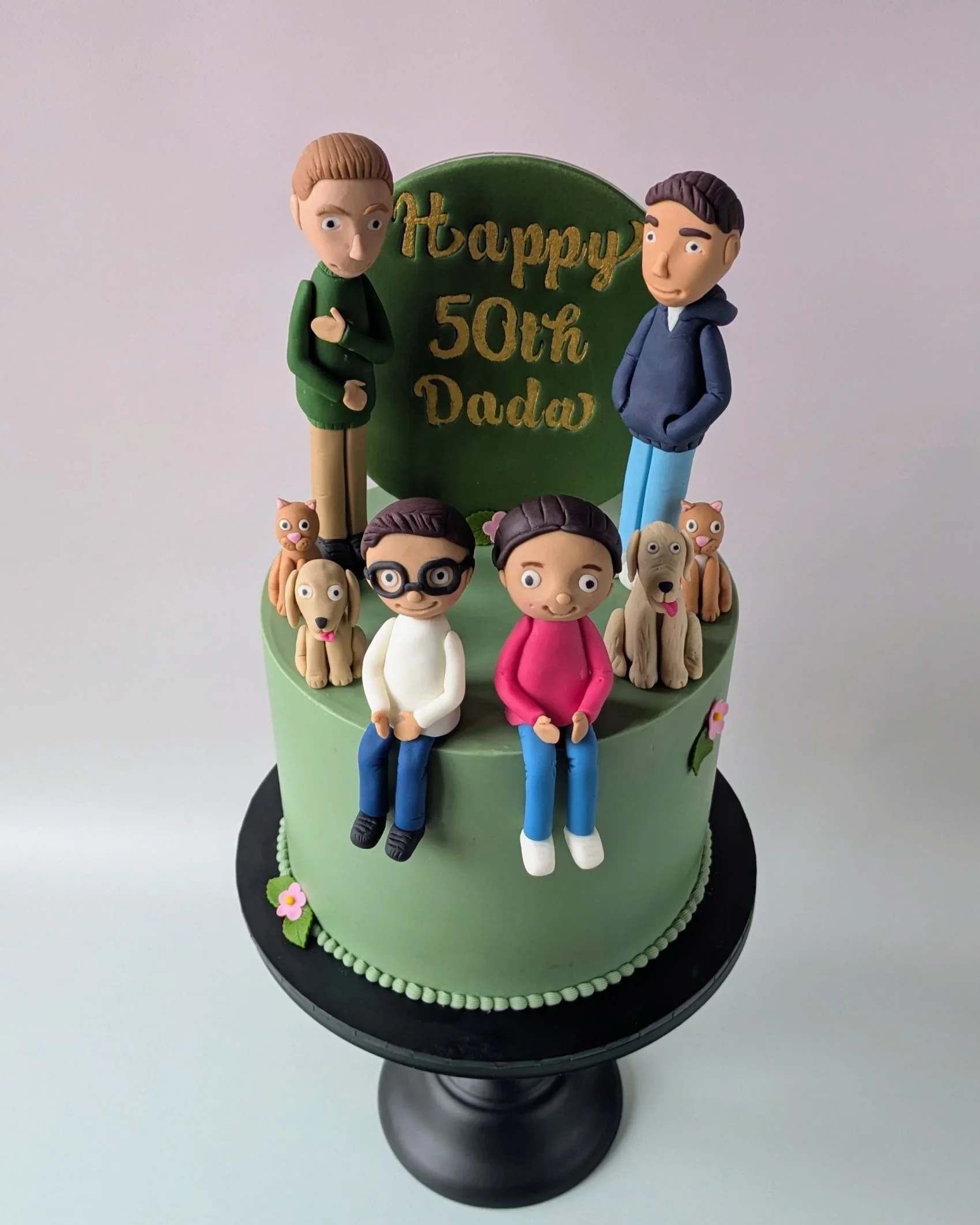 Custom 50th birthday cake featuring handmade family figurines of two dads and kids, Bristol vegan cake shop
