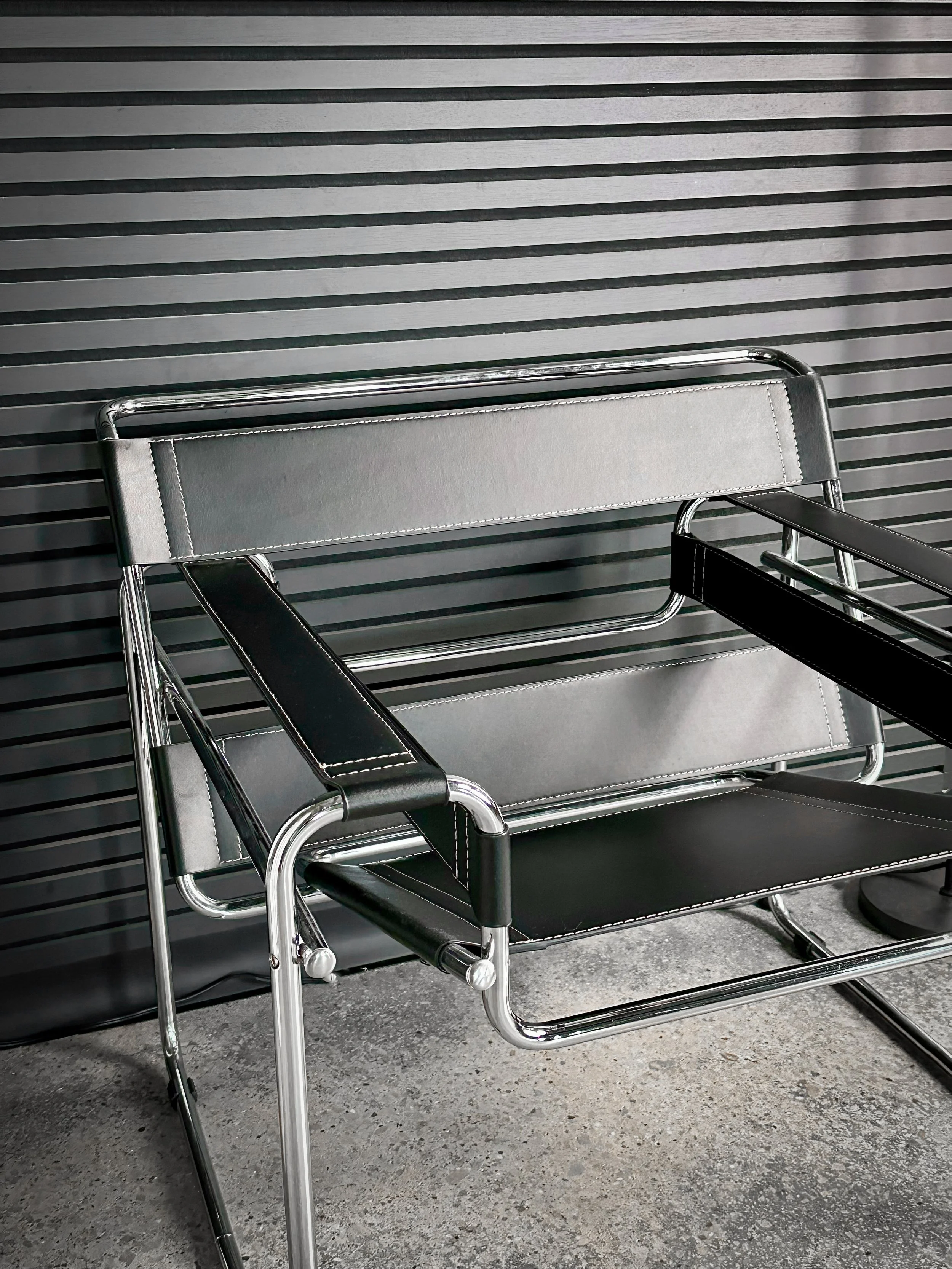 Black leather chair against a slat wall at d14 Studio, an industrial-modern photography and content studio in Madison Heights, serving Metro Detroit.