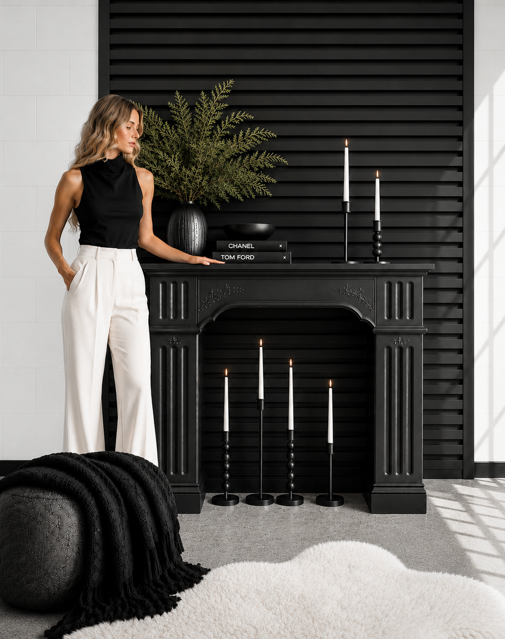 Woman posing beside the black Noir Mantel set at d14 Studio, styled with taper candles, greenery, black slat wall and editorial décor.