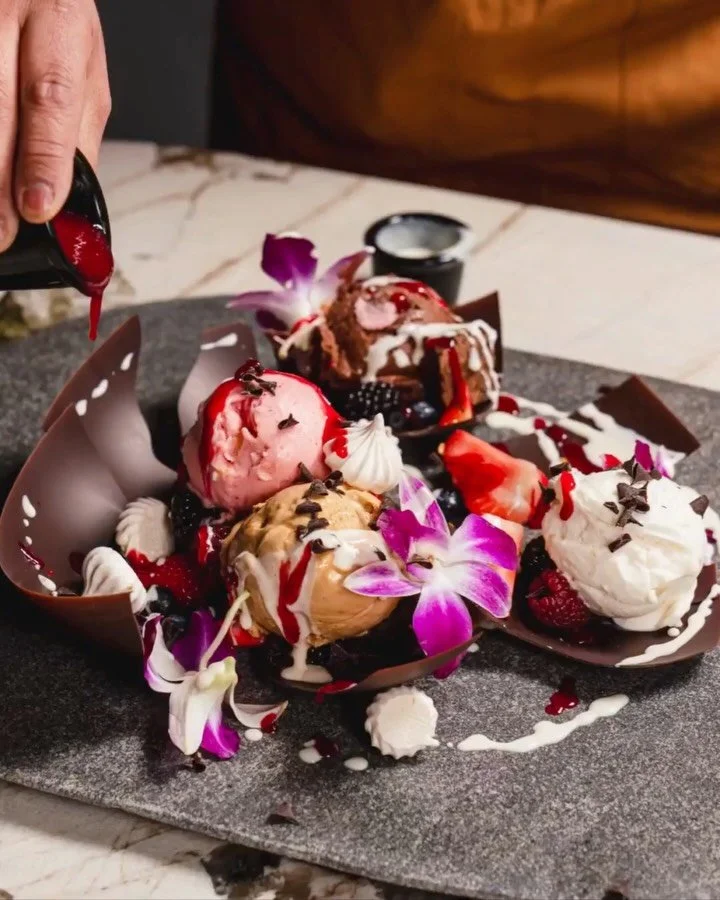 A show-stopping end your evening: La Bomba! 💣
Our chocolate half-sphere, filled with a selection of housemade ice cream and cookies, cracked at your table and topped with fruit coulis.