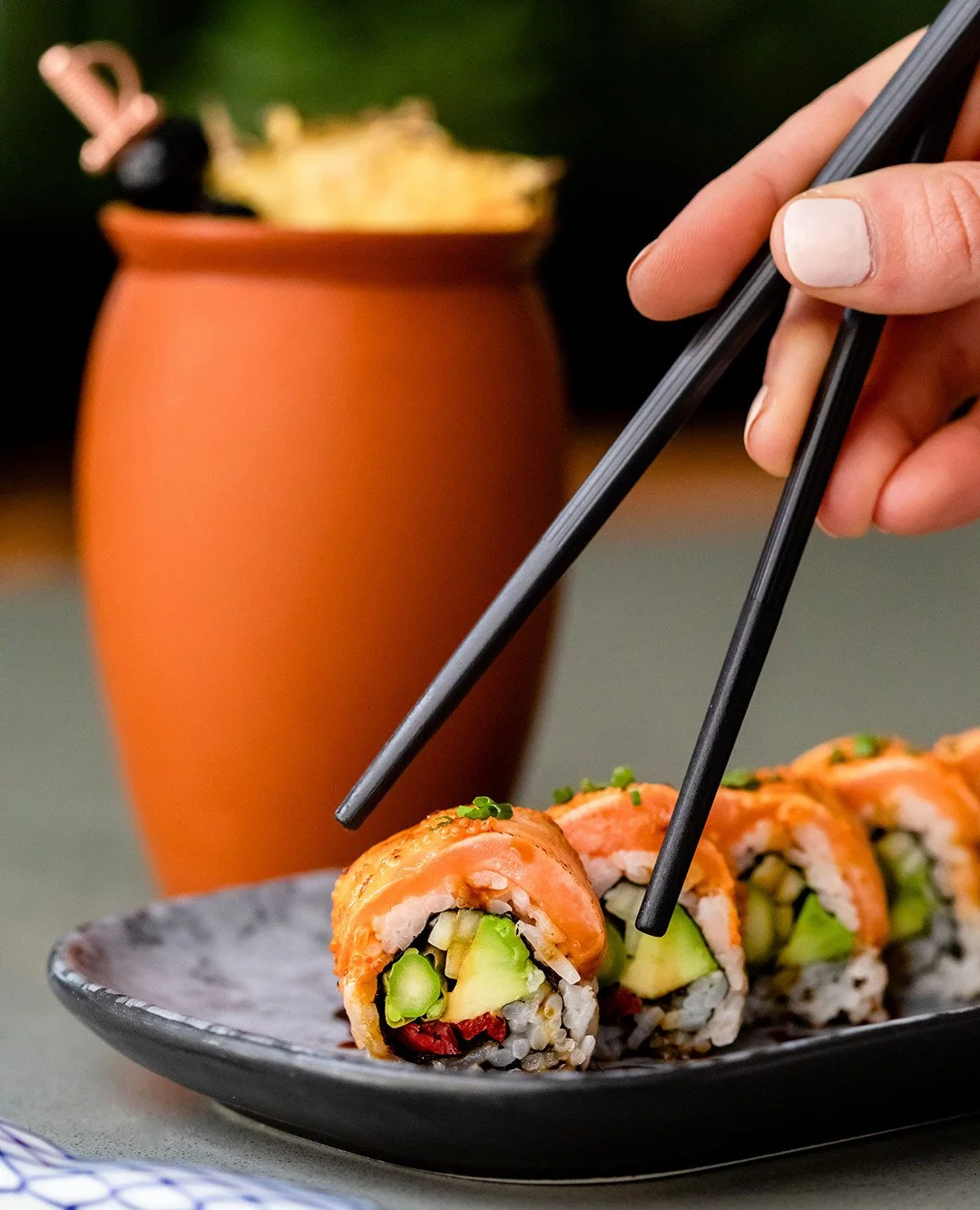 One slice in and the story unfolds. Flamed salmon, chipotle aioli, and a pop of tobiko wrapped with avocado, scallion, sundried tomato, and cucumber, finished in kabayaki sauce a little heat, a little smoke, all Toro. Eye of the tigre.