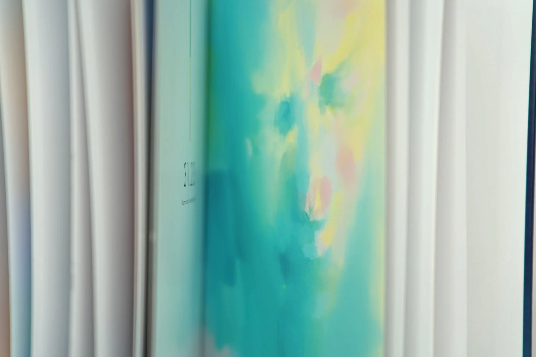 Buch mit buntem, abstraktem Cover, das leicht seitlich fotografiert ist.