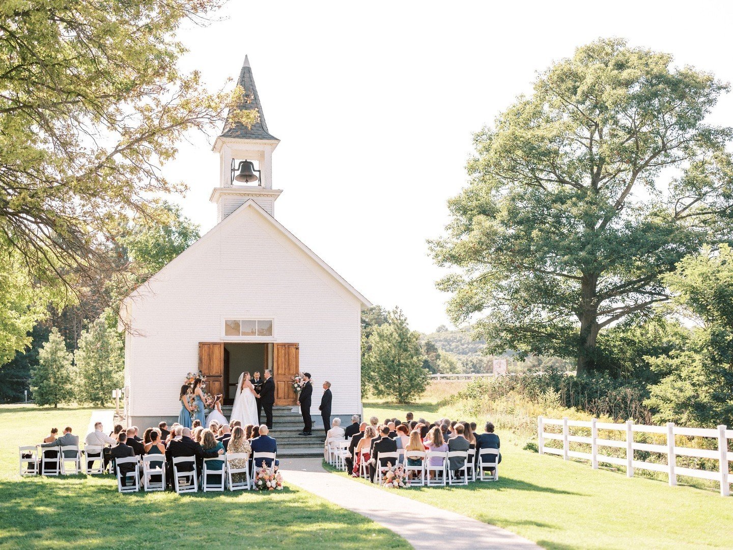 We can't get over how gorgeous the ceremony was at the historic, white chapel in Saugatuck. It's so classic and picturesque! We love how the bright, colorful floral arrangements just pop against the white chapel and chairs. Don't you?! ⁠
⁠
Planning +