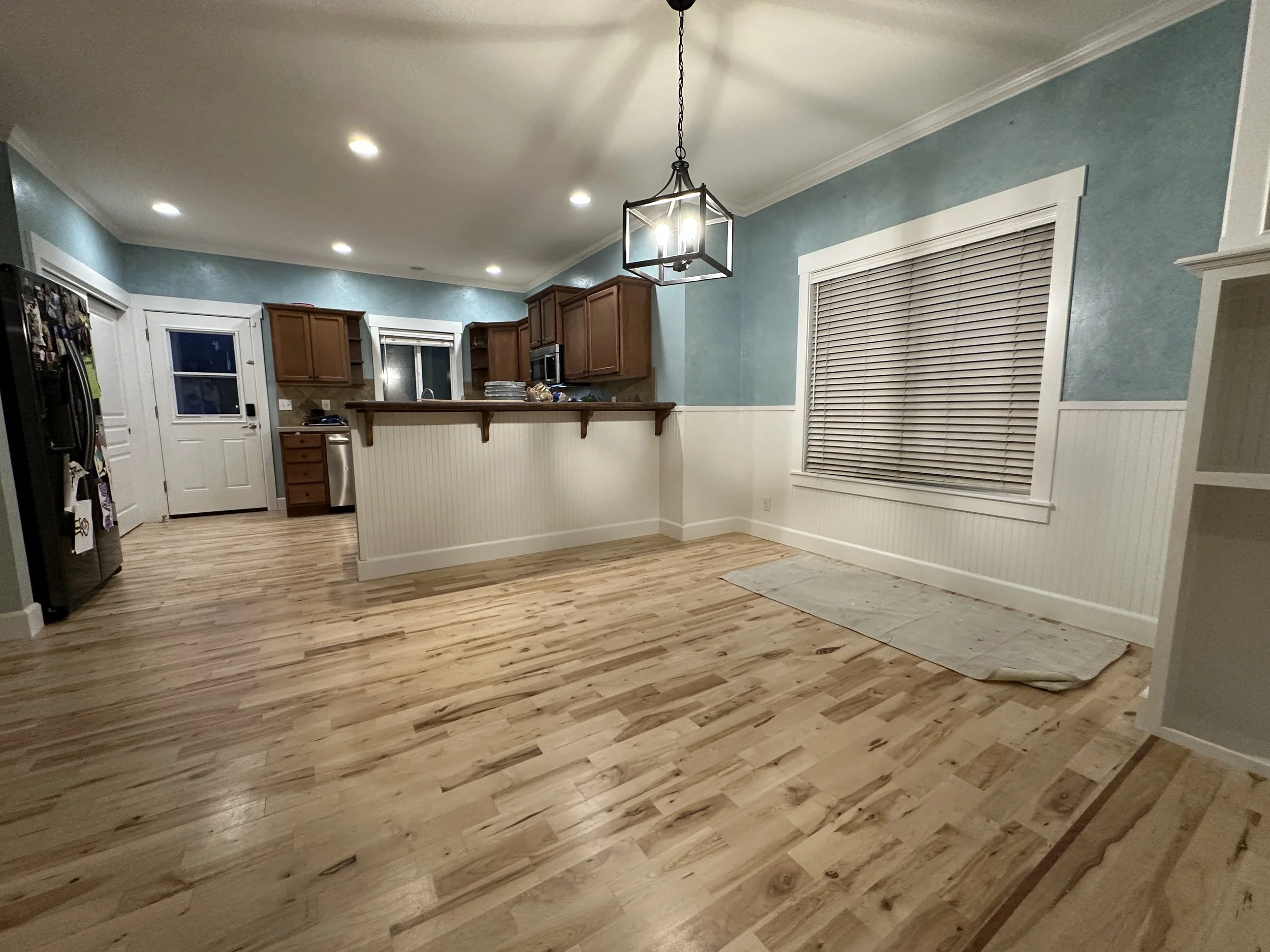 wide angle of kitchen that is painted blue walls and white trim with moody lighting