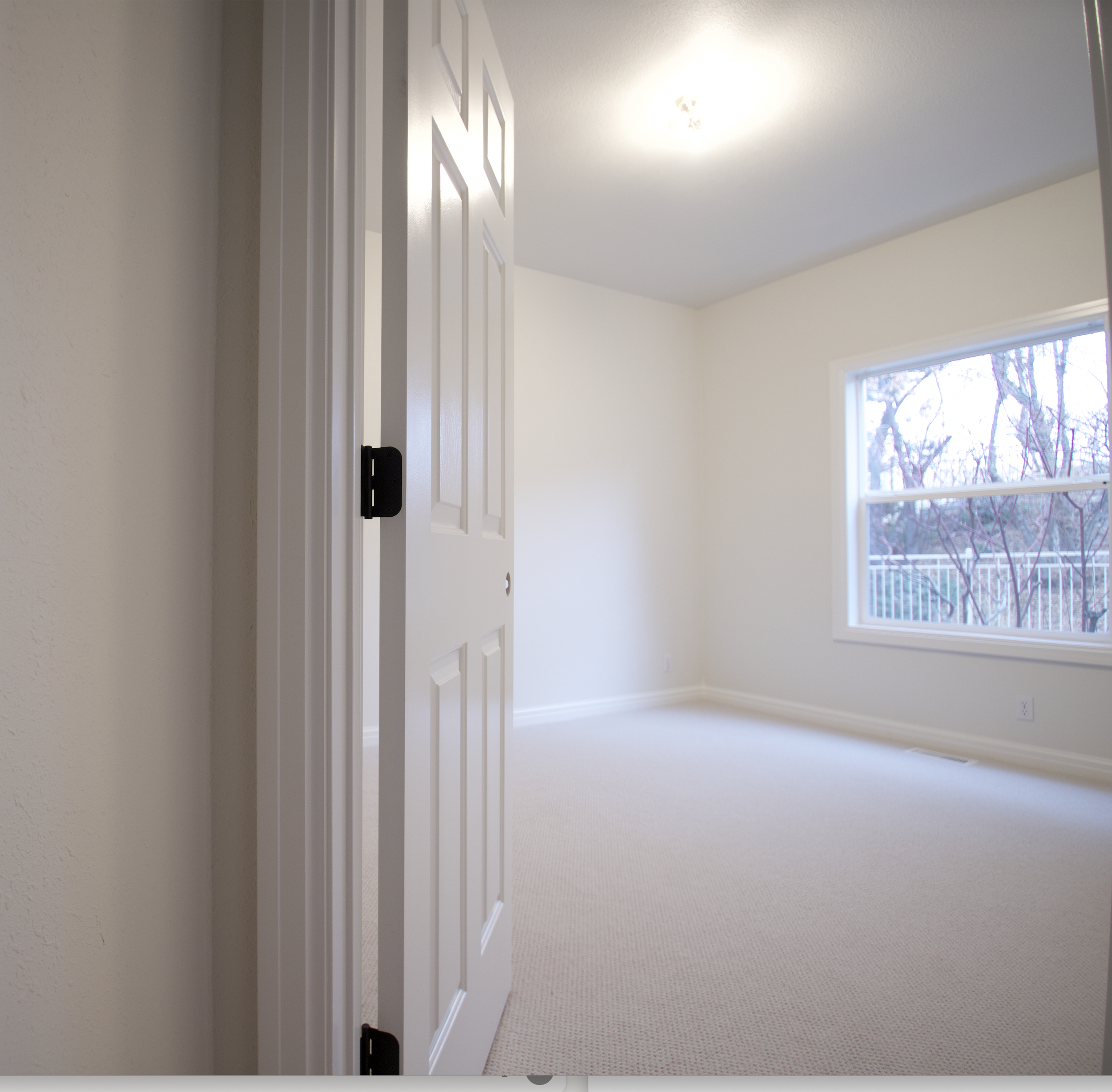 picture of open door with shiny white paint and creamy colored painted walls