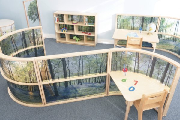 Privacy walls with trees on them divide a classroom in two halves. 