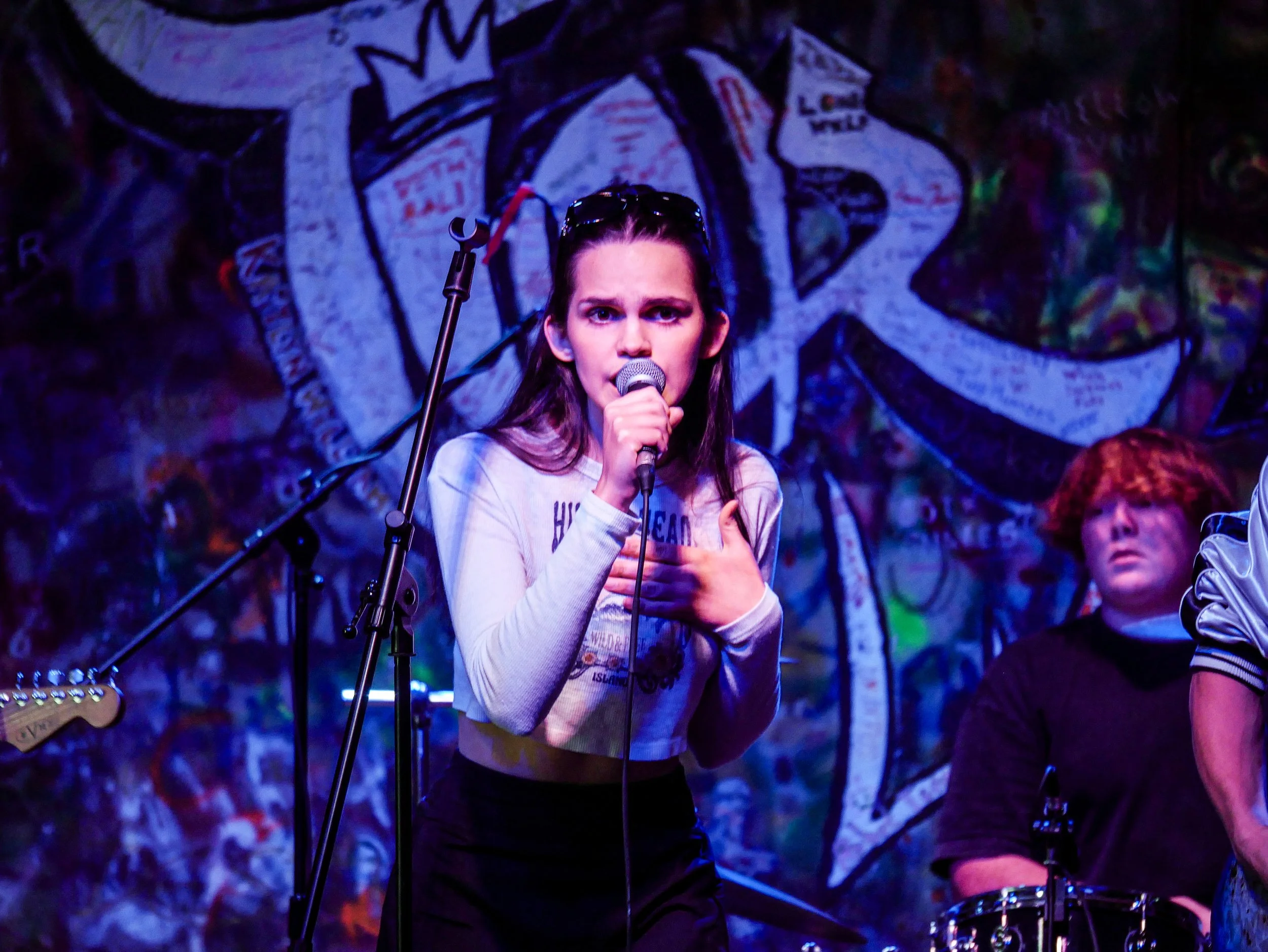 A young lady looks into the camera while singing at the Tier Two Live Youth Battle of the Bands