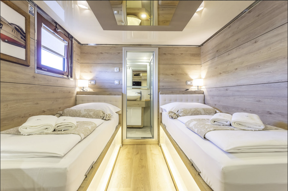 Ensuite yacht cabin with twin beds and a mirrored ceiling