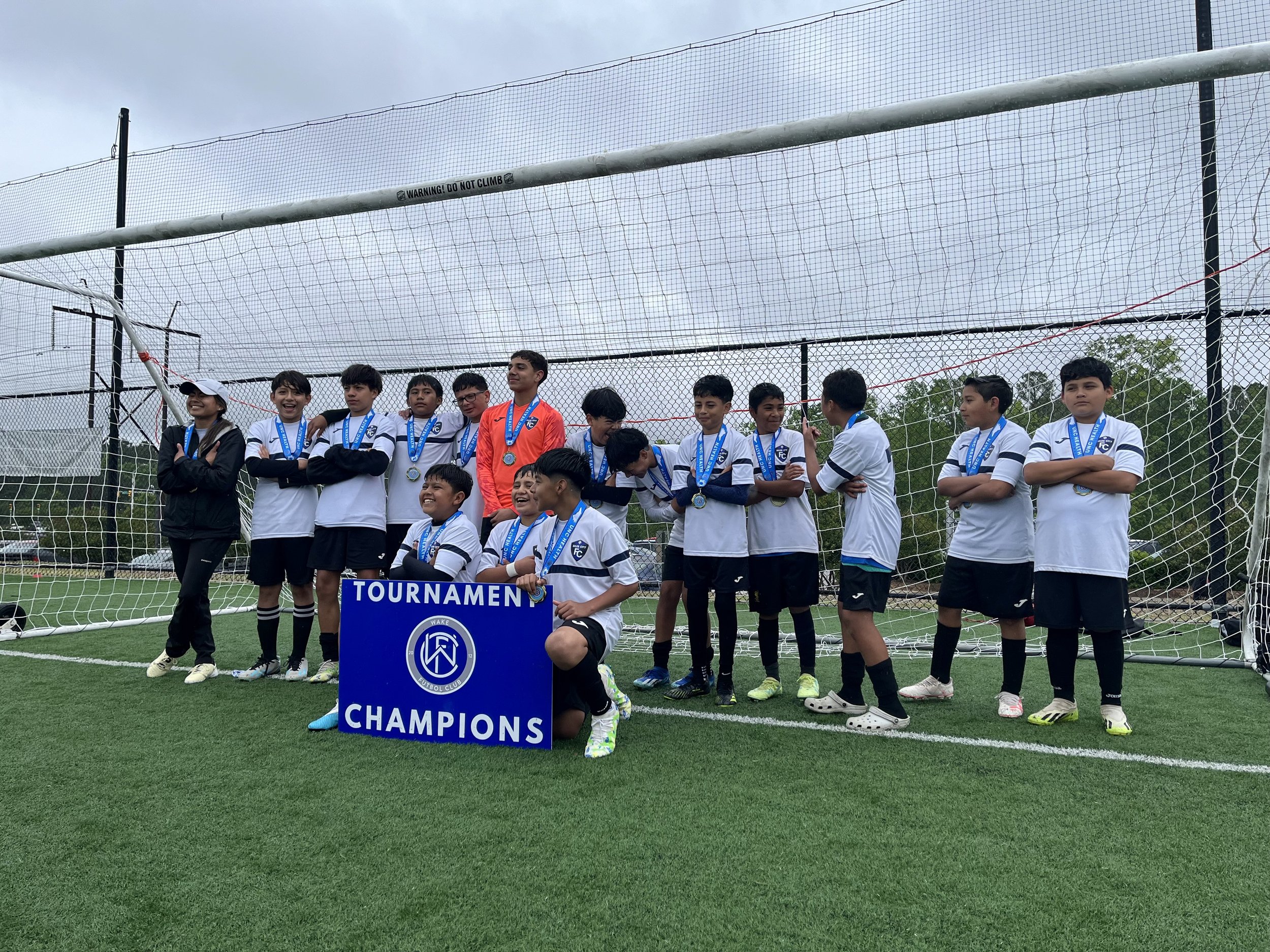Youth soccer team with medals celebrating tournament victory on field