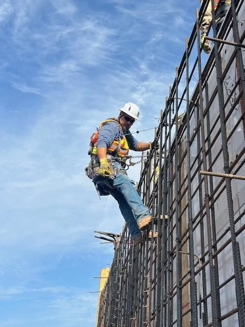 Construction worker in safety gear working on scaffolding at a construction site