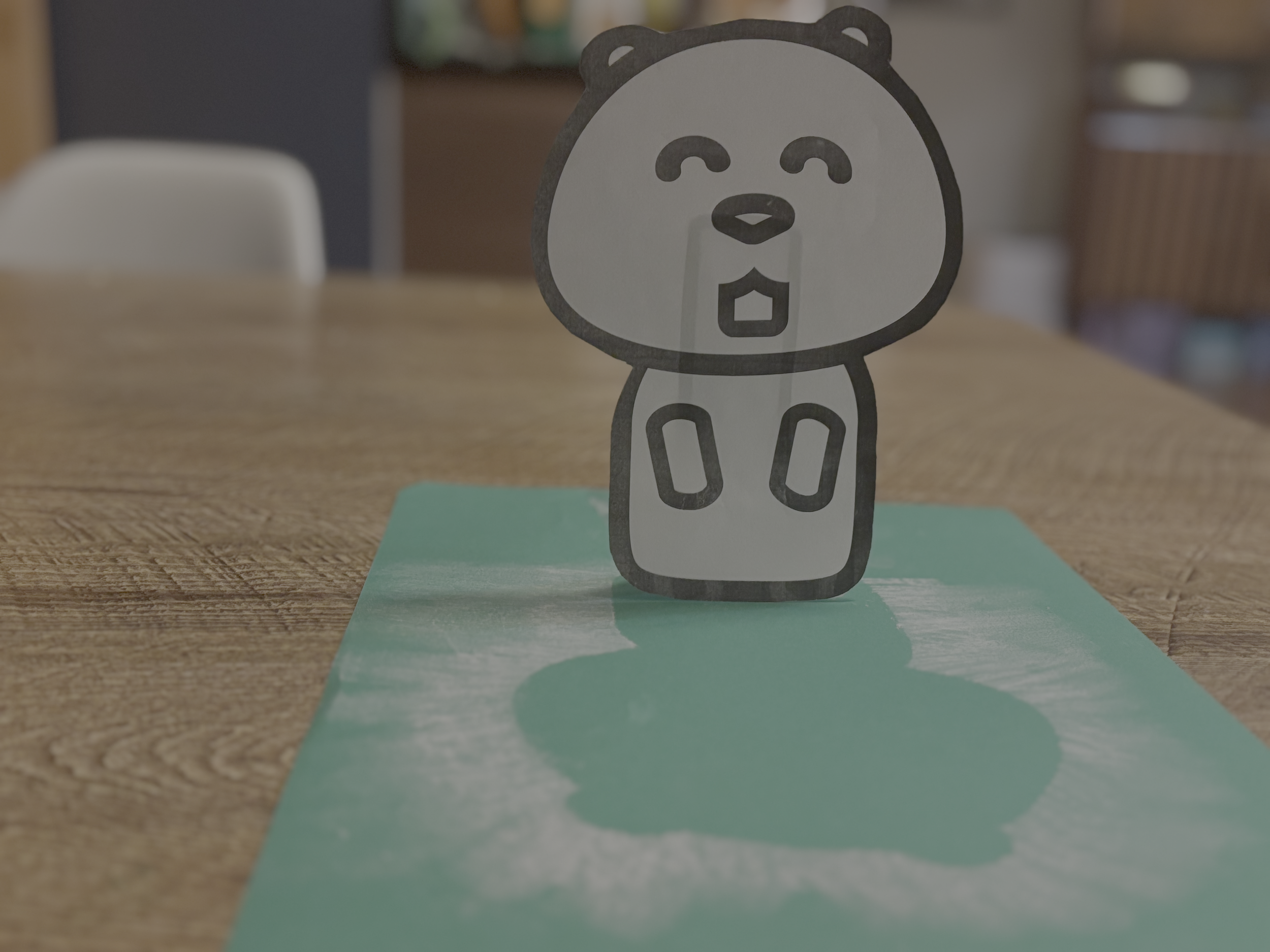 A paper groundhog standing in front of it's "shadow" made of chalk.