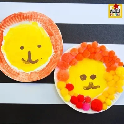two lions made from painted paper plates.  One has a pom pom mane